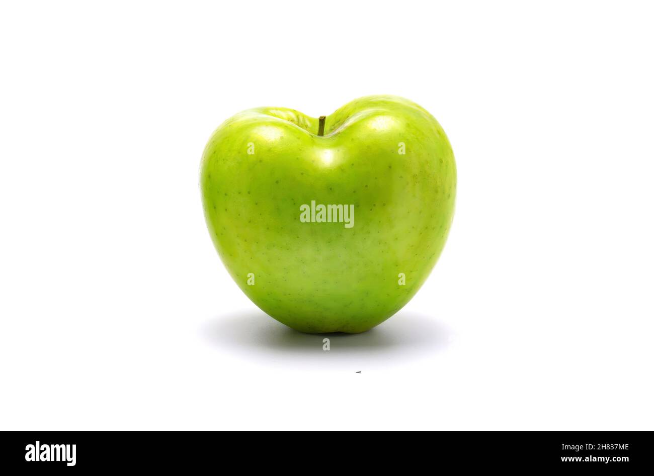 Grüner Apfel herzförmig. Auf weißem Hintergrund. Stockfoto