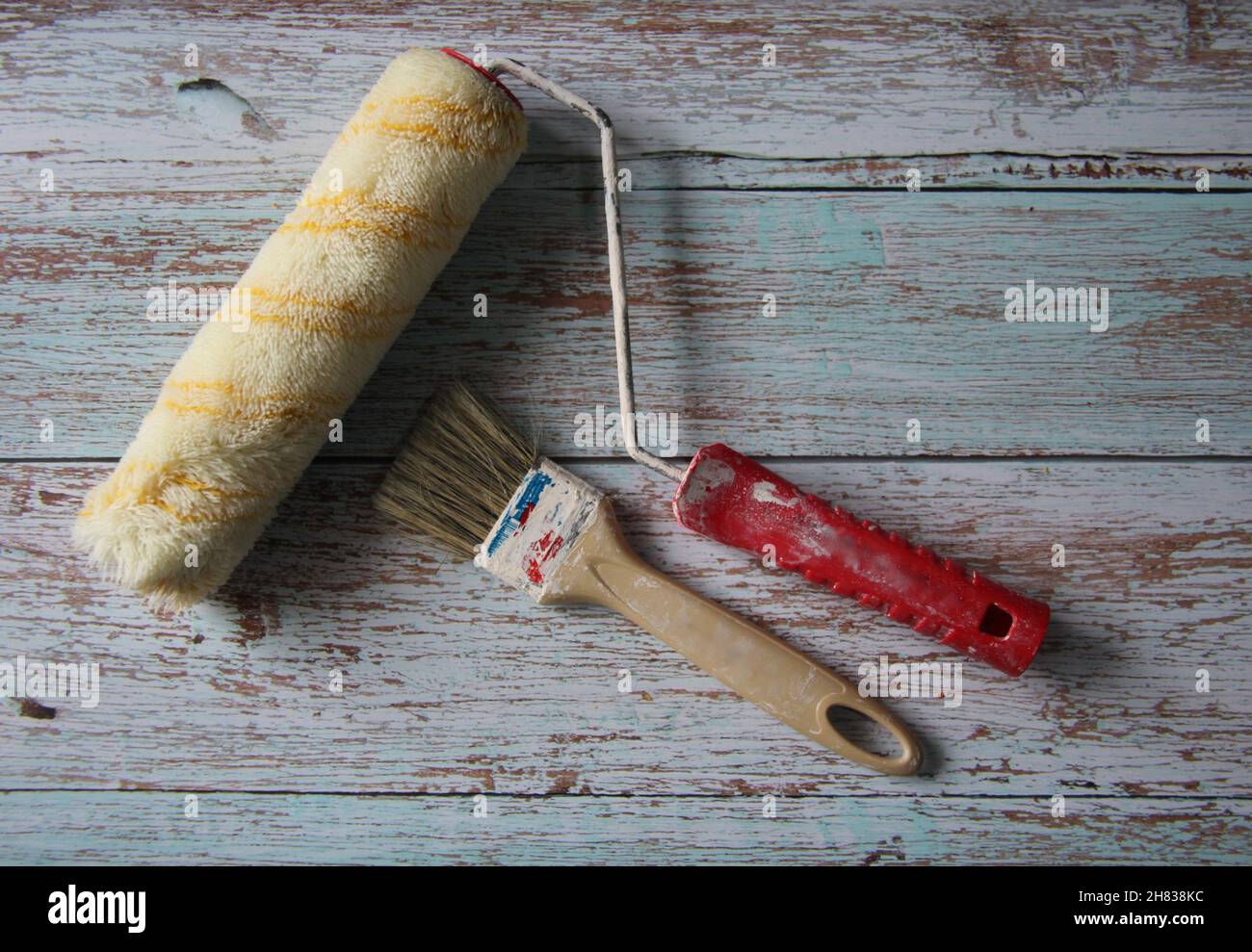 Zwei verschiedene Arten von Farbbürsten auf einem alten Holztisch. Stockfoto