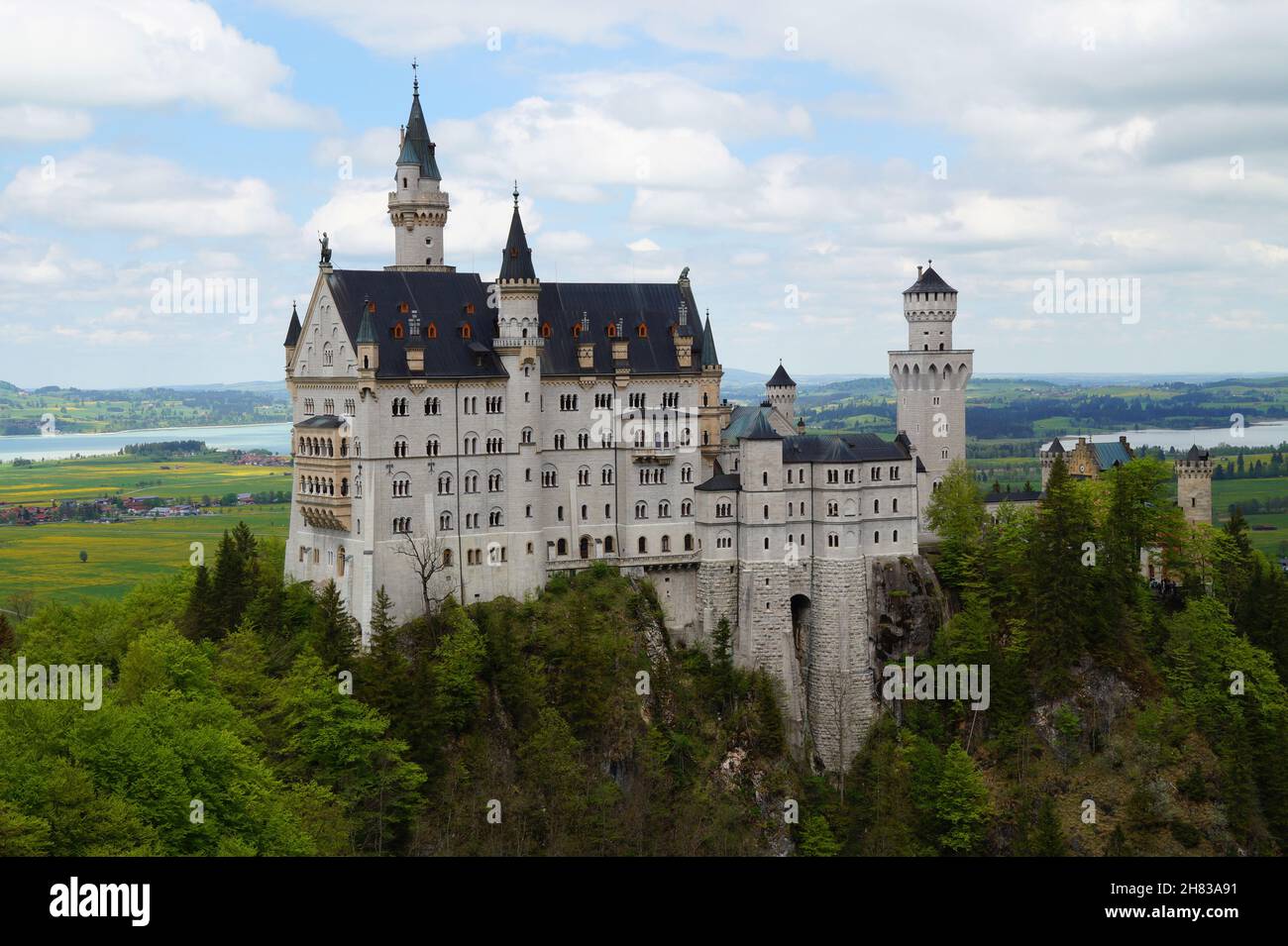 Bayerisches Schloss Neuschwanstein in den Alpen und Forggensee im Hintergrund fotografiert von der Marienbrücke (Bayern, Deutschland) Stockfoto