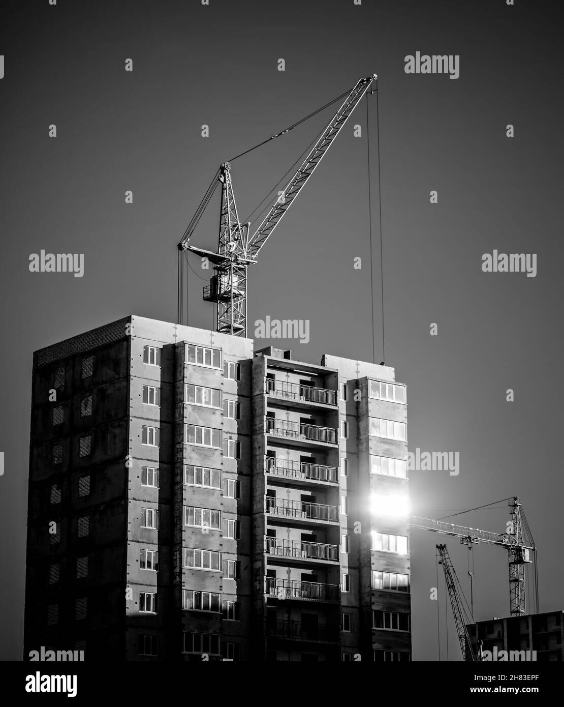 Silhouetten der industriellen Baukräne und Gebäude Stockfoto