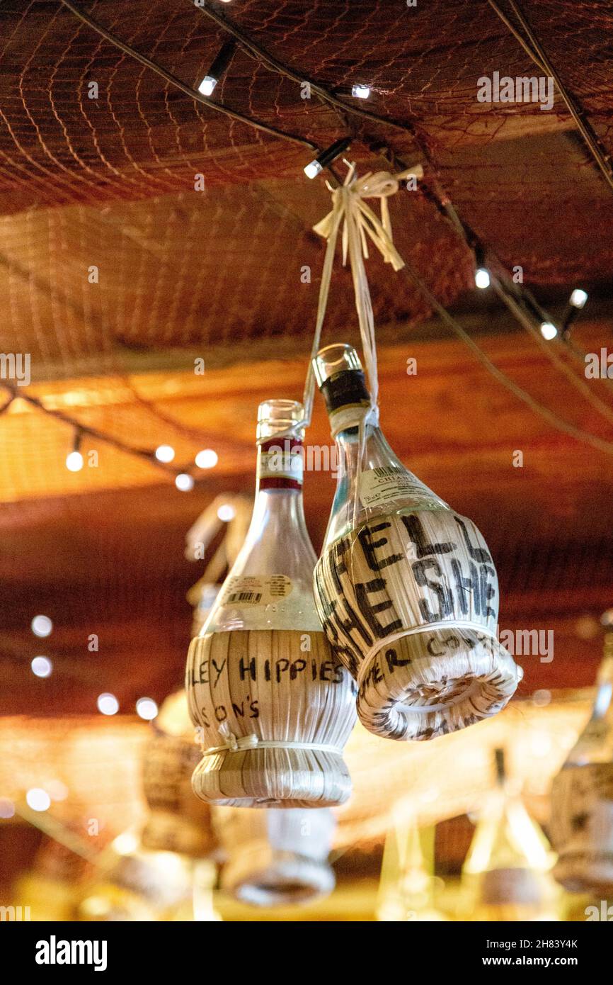 Alkoholflaschen, die im Meerjungfrau-Fischrestaurant, St Ives, Cornwall, Großbritannien, von der Decke hängen Stockfoto