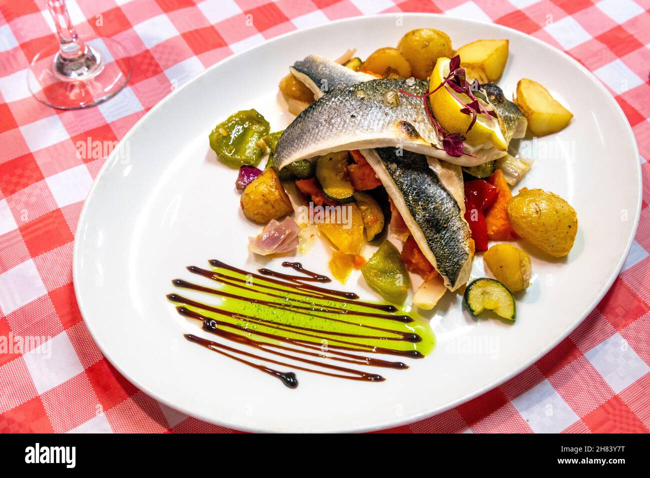 Seebarschfilets, mediterranes Gemüse und neue Kartoffeln im Meerjungfrau-Fischrestaurant, St Ives, Cornwall, Großbritannien Stockfoto