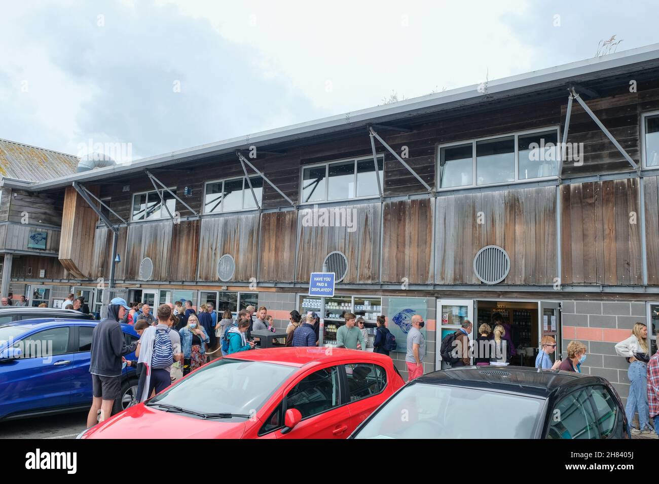 Padstow, Großbritannien – 2021. Juli: Kunden, die vor Stein's Deli am Padstow-Flussufer Schlange stehen. Stockfoto