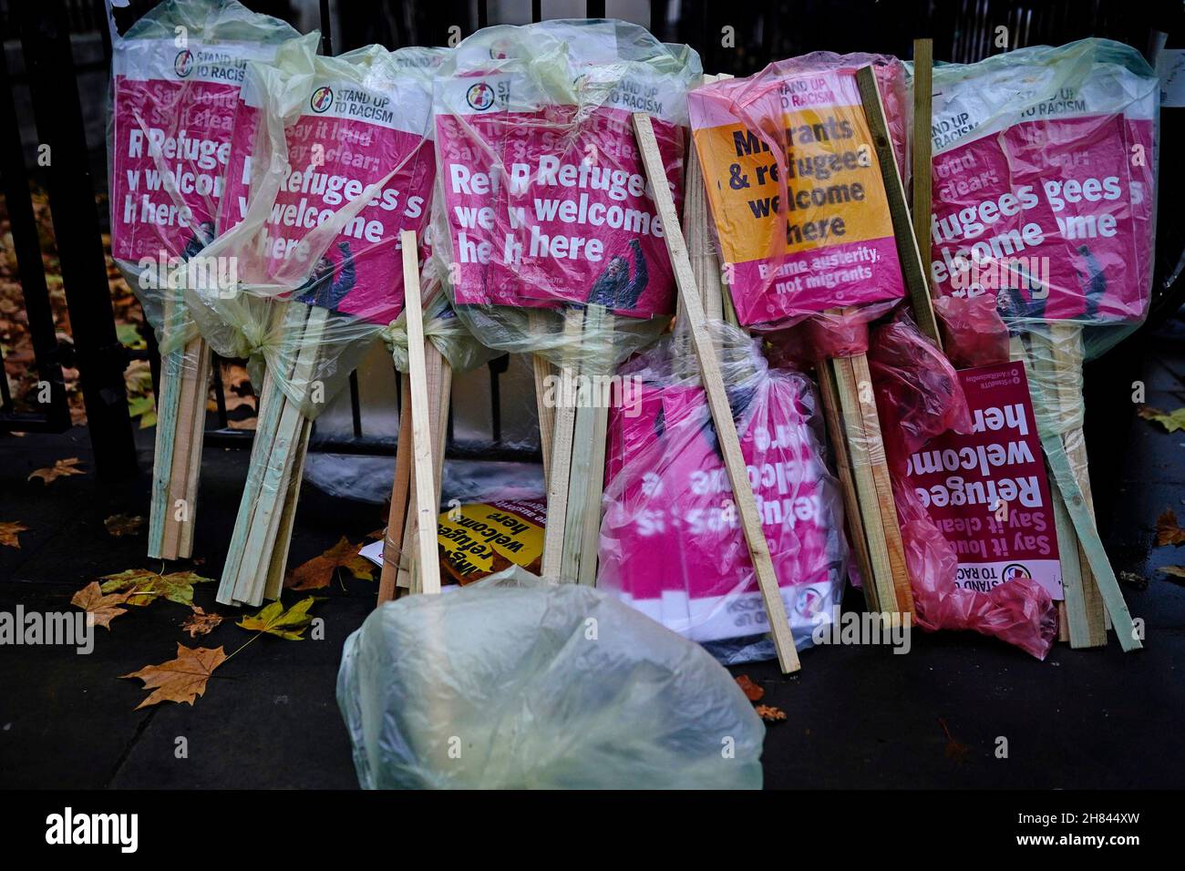 Plakate, die in Taschen gewickelt waren, um sich vor dem Regen zu schützen, während eines Protestes vor der Downing Street in Westminster, London, mit dem Aufruf an die Regierung, die Gesetze und Gesetze der Nationalitäten und Grenzen zu streichen und die sichere und legale Route für Flüchtlinge, die nach Großbritannien einreisen und Asyl beantragen, schnell auszuweiten. Bilddatum: Samstag, 27. November 2021. Stockfoto