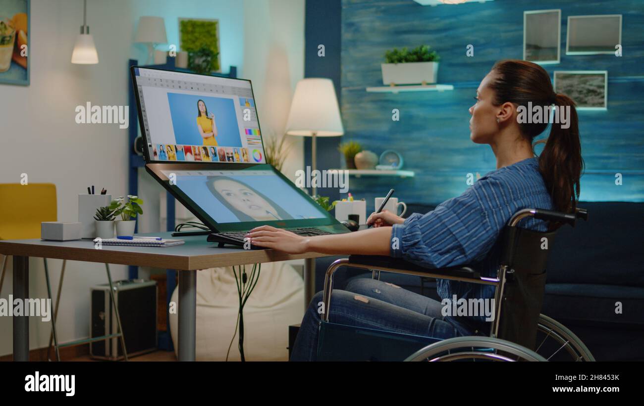 Künstler mit Handicap Retusche Bilder auf Touchscreen Computer im Fotostudio. Grafikeditor im Rollstuhl sitzend und mit Bearbeitungssoftware und Tablet für die Medienproduktion Stockfoto