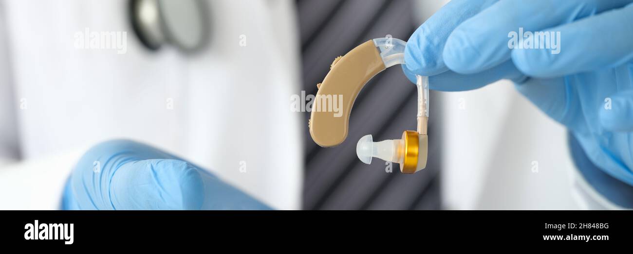 Arzt Otorhinolaryngologe, der Hörgeräte in der Nähe in den Händen hält Stockfoto