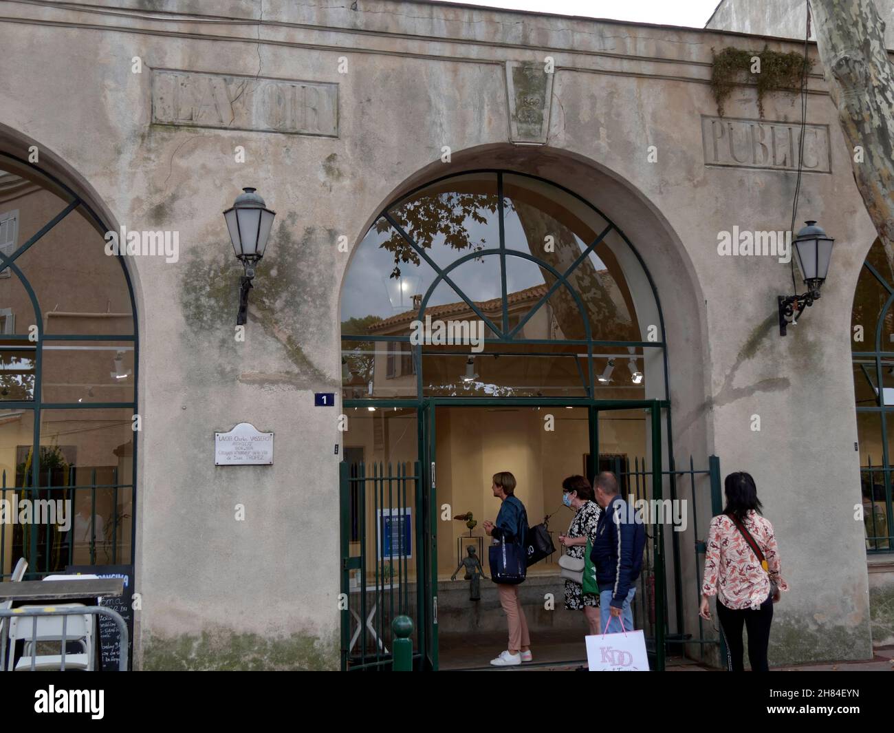 Vor dem alten öffentlichen Lavoir stehen die Leute, um eine Kunstausstellung zu sehen, Saint-Tropez, Var, Provence-Alpes-Côte d'Azur Region, Frankreich Stockfoto