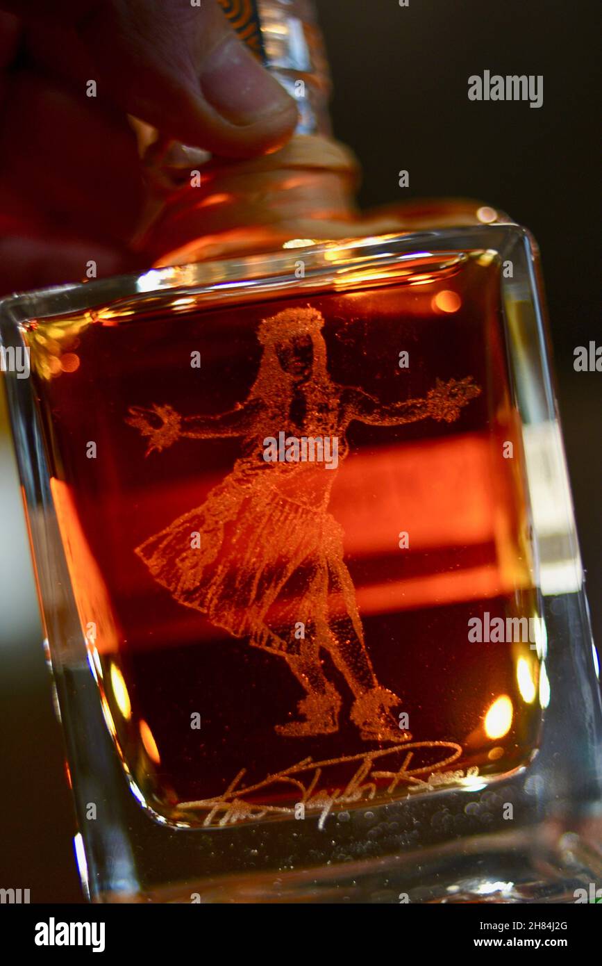 Hawaianisches Mädchen tanzt Hula, geätzt auf die Glasflasche gefüllt mit bernsteinfarbenem Kō Hana Hawaiian Agricole Rum, Kō Hana Distillers, Kunia, Hawaii, USA Stockfoto