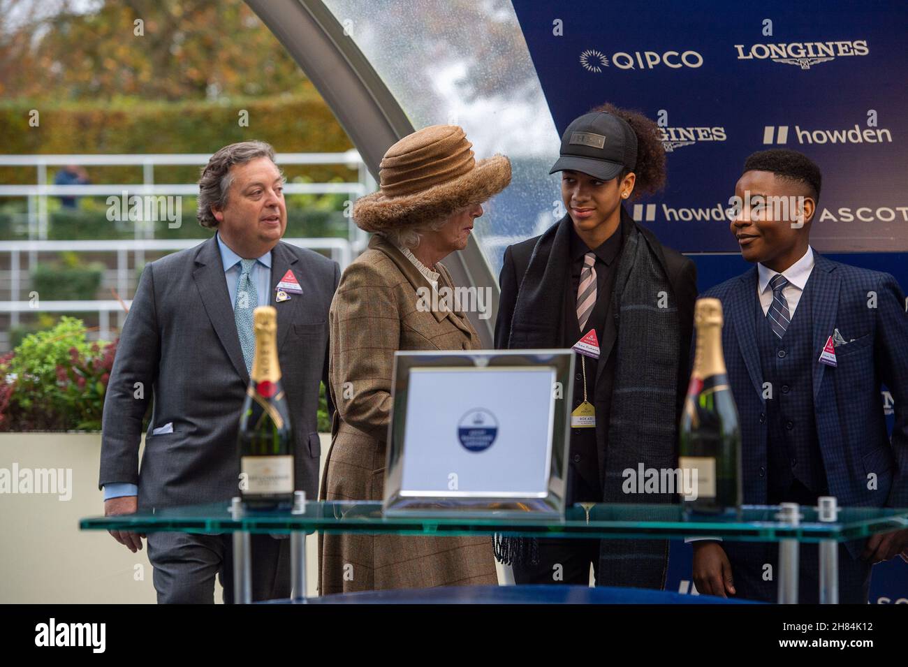 Ascot, Bergen, Großbritannien. 20th. November 2021. Camilla, Herzogin von Cornwall und Präsidentin des Ebony Horse Clubs in Brixton, unterhielt sich mit Jugendlichen des Ebony Horse Clubs, der jungen Menschen hilft, Reiten zu lernen und ihnen Selbstvertrauen zu geben. Nachdem der „Limited Handicap Steeple“ des Ebony Horse Clubs von Jockey Bryony Frost auf Pferd Jeremy Pass gewonnen wurde, hielt die Herzogin die Präsentation vor dem Bräutigam des Pferdes, einem Vertreter von Trainer Paul Nicholls und dem siegreichen Jockey Bryony Frost in Begleitung von Mitgliedern des Ebony Horse Clubs Credit: Maureen McLean/Alamy Stockfoto