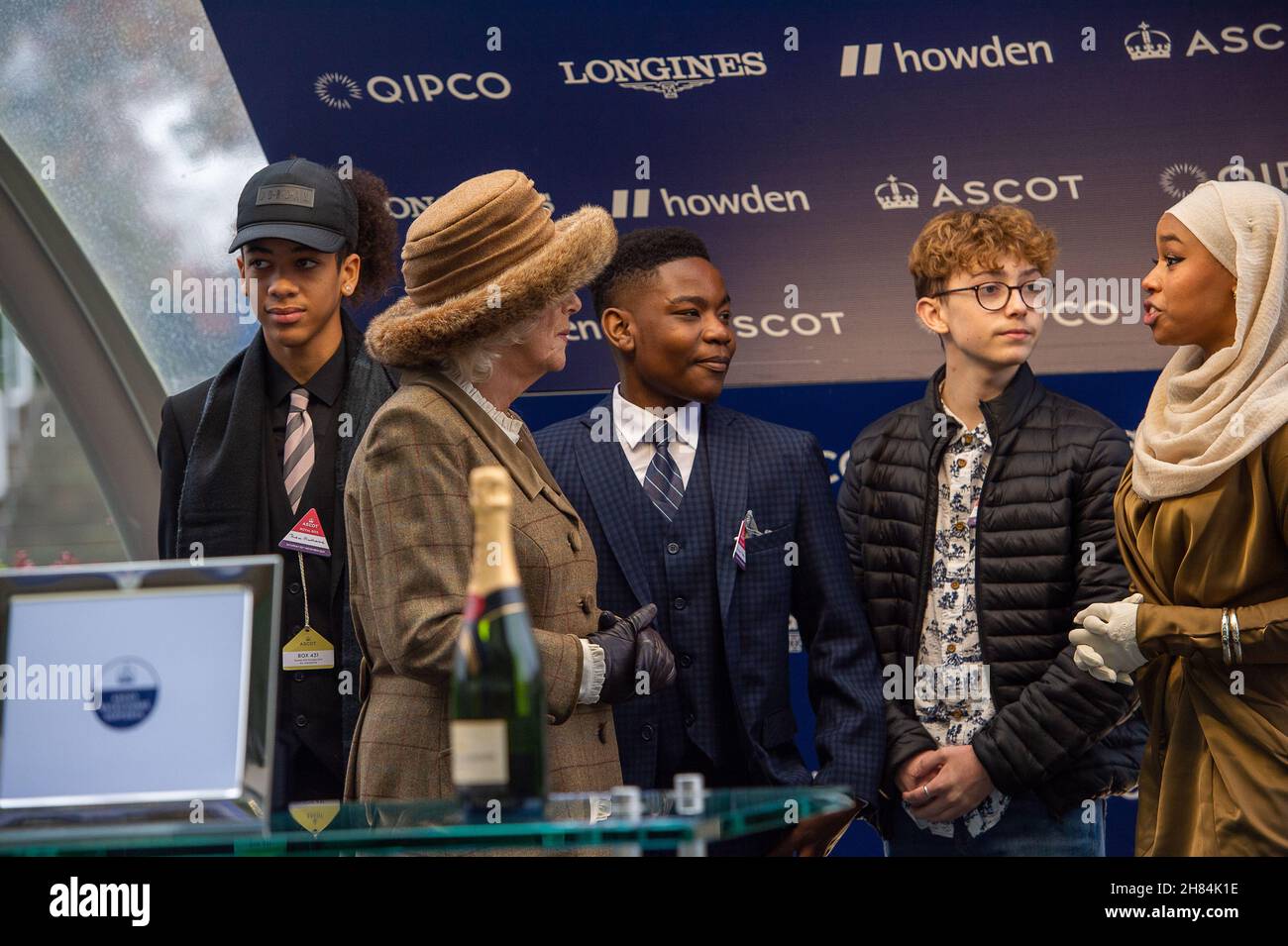 Ascot, Bergen, Großbritannien. 20th. November 2021. Camilla, Herzogin von Cornwall und Präsidentin des Ebony Horse Clubs in Brixton, unterhielt sich mit Jugendlichen des Ebony Horse Clubs, der jungen Menschen hilft, Reiten zu lernen und ihnen Selbstvertrauen zu geben. Nachdem der „Limited Handicap Steeple“ des Ebony Horse Clubs von Jockey Bryony Frost auf Pferd Jeremy Pass gewonnen wurde, hielt die Herzogin die Präsentation vor dem Bräutigam des Pferdes, einem Vertreter von Trainer Paul Nicholls und dem siegreichen Jockey Bryony Frost in Begleitung von Mitgliedern des Ebony Horse Clubs Credit: Maureen McLean/Alamy Stockfoto