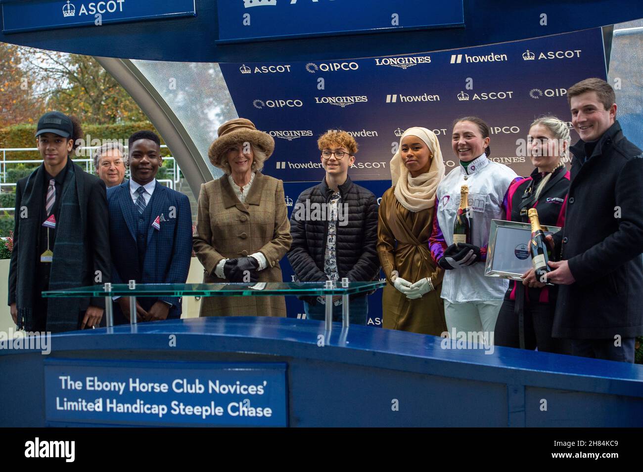 Ascot, Bergen, Großbritannien. 20th. November 2021. Camilla, Herzogin von Cornwall und Präsidentin des Ebony Horse Clubs in Brixton, unterhielt sich mit Jugendlichen des Ebony Horse Clubs, der jungen Menschen hilft, Reiten zu lernen und ihnen Selbstvertrauen zu geben. Nachdem der „Limited Handicap Steeple“ des Ebony Horse Clubs von Jockey Bryony Frost auf Pferd Jeremy Pass gewonnen wurde, hielt die Herzogin die Präsentation vor dem Bräutigam des Pferdes, einem Vertreter von Trainer Paul Nicholls und dem siegreichen Jockey Bryony Frost in Begleitung von Mitgliedern des Ebony Horse Clubs Credit: Maureen McLean/Alamy Stockfoto