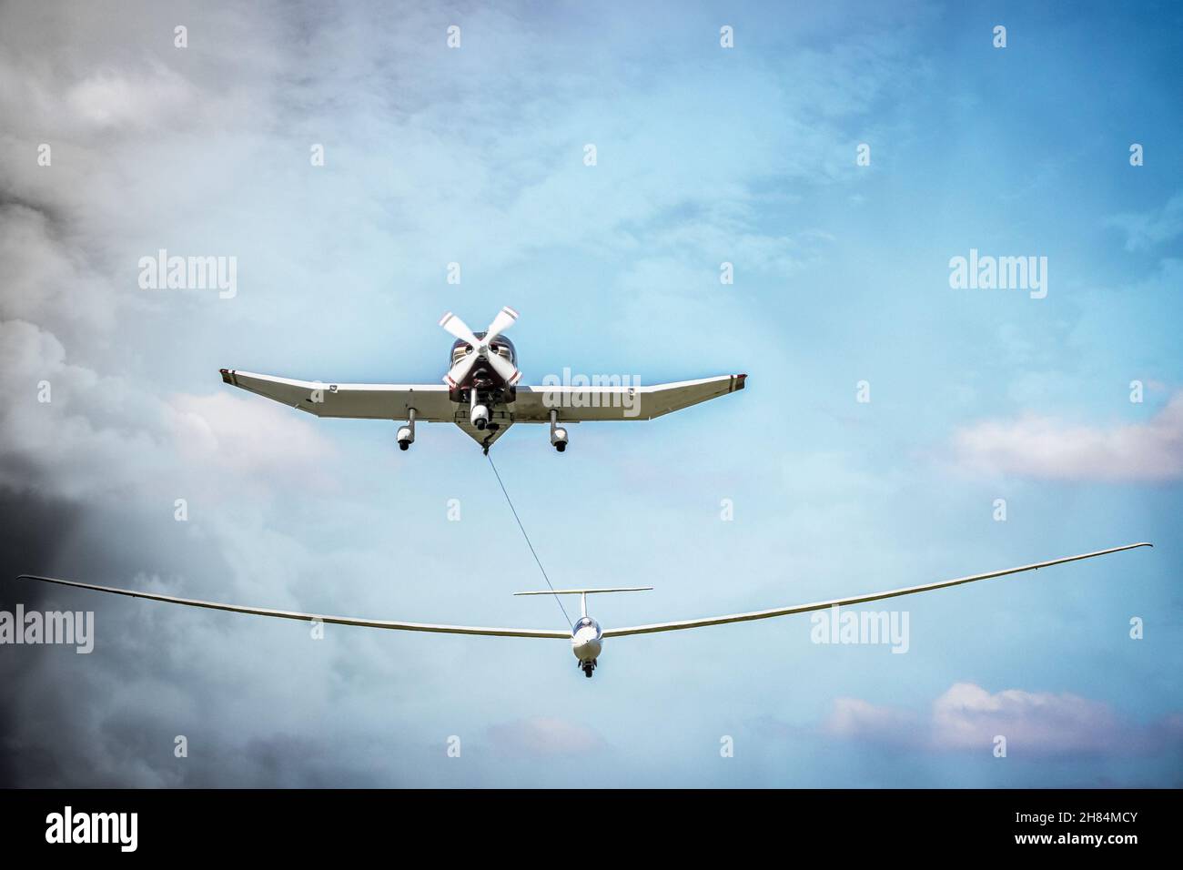 Ein einmotoriger Flieger, der einen Segelflieger in die Höhe einer Kreuzfahrt schleppt Stockfoto