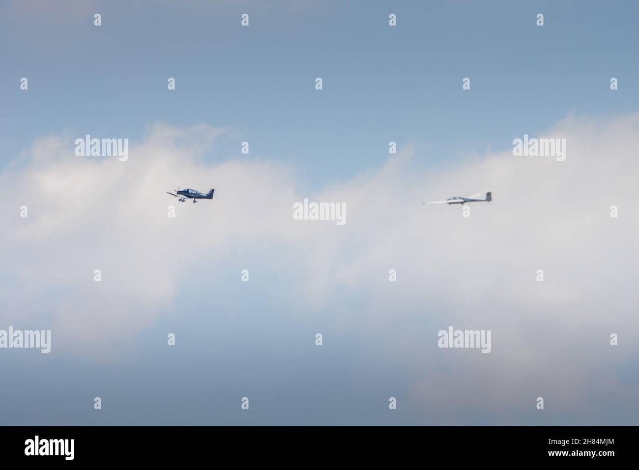 Ein einmotoriger Flieger, der einen Segelflieger in die Höhe schleppt Stockfoto