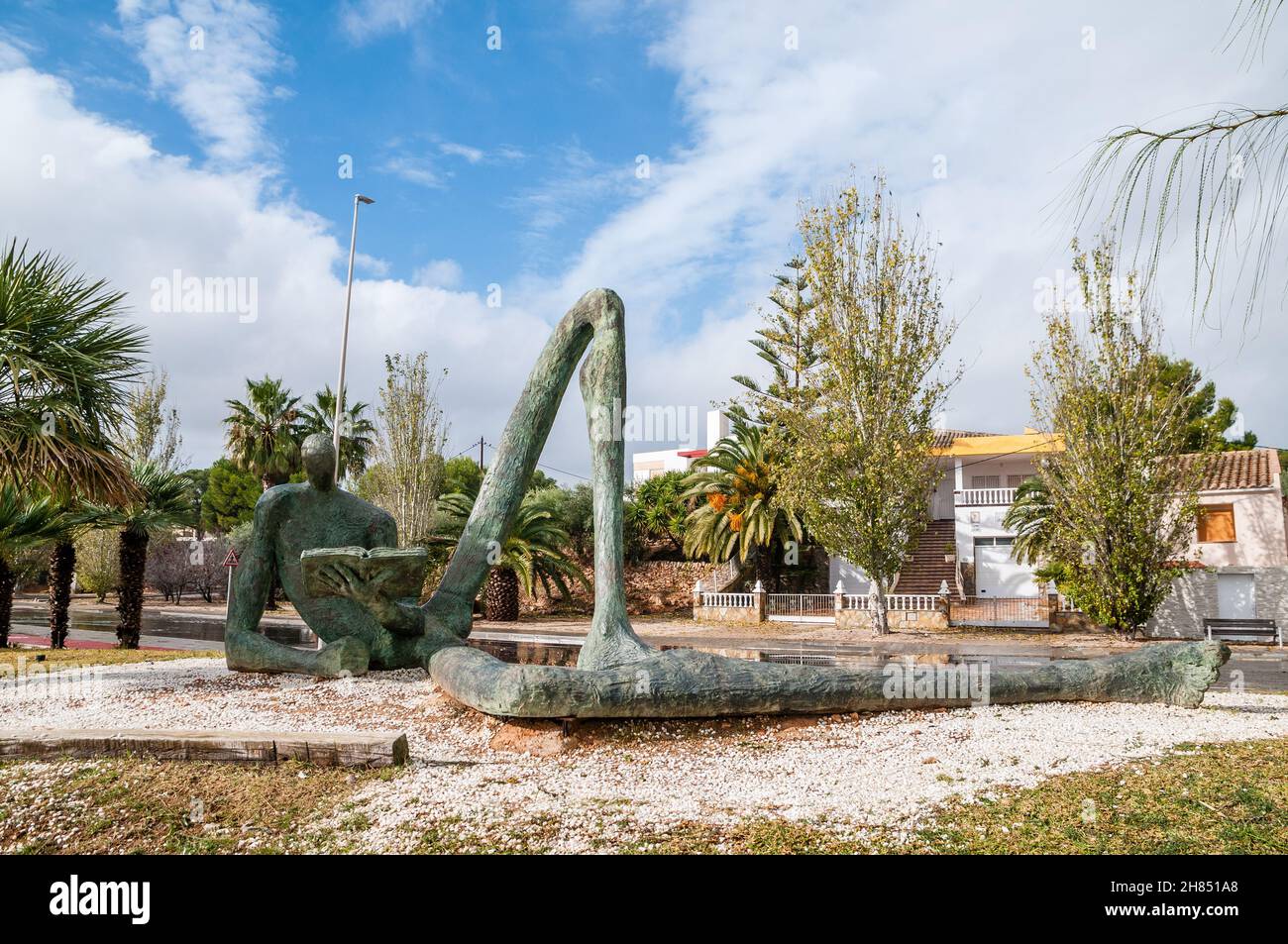 Der Odyssey-Leser, Bronzeskulptur mit der Figur eines sitzenden Mannes, umrissen, mit überproportional langen Gliedmaßen und einem der Beine, die eine Brid bilden Stockfoto