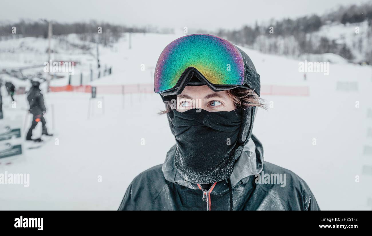 Skimorträt. Eisgekühlte Skibrillen und Skihelm wurden auf einen Mann aufgefahren, der die Kamera ansah, während die Skibrille im Frost vereißert war. Konzept von Glaze Ice, auch Stockfoto