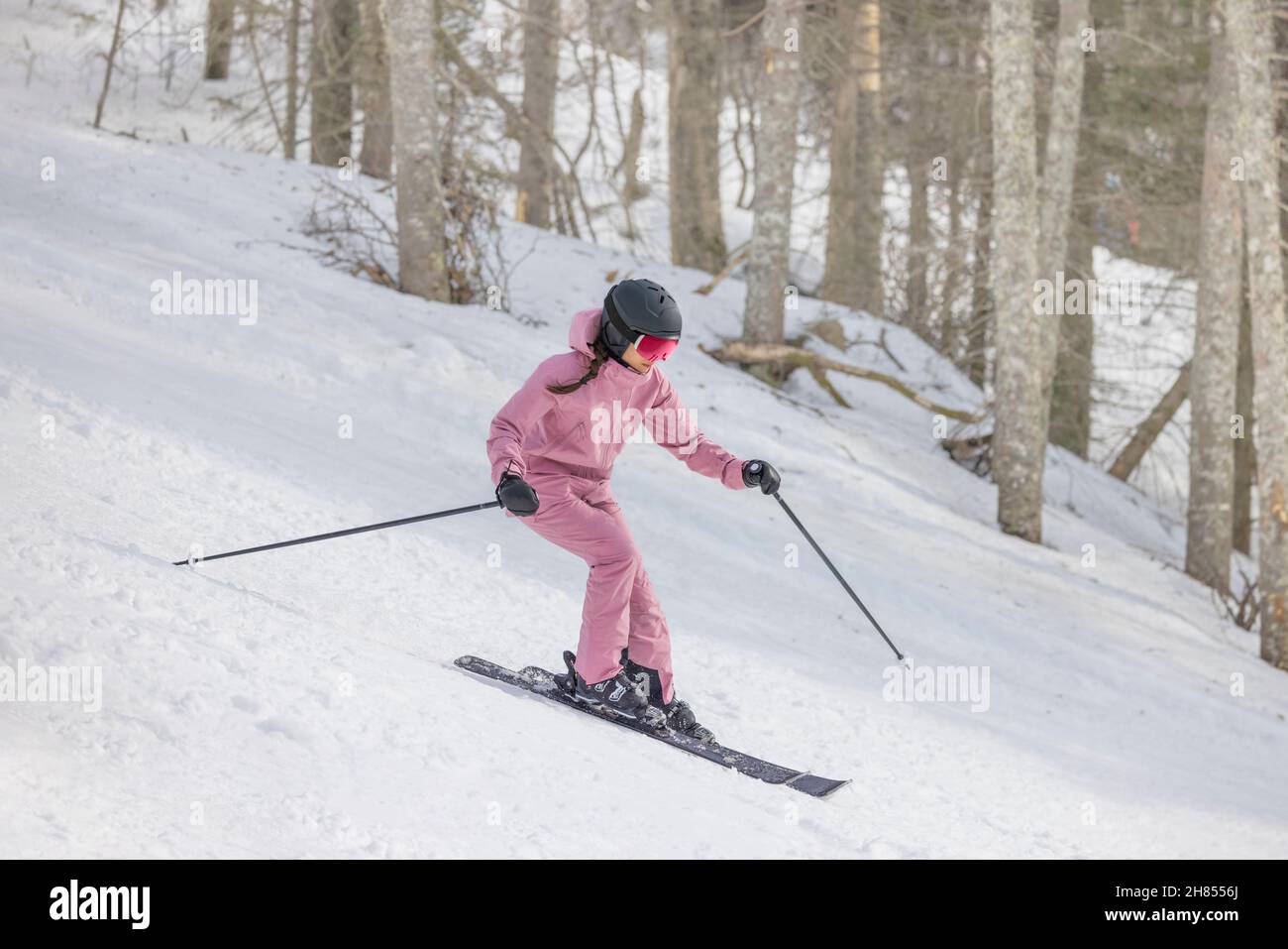 Alpine Skiing Abfahrt. Frau auf Ski Abfahrt Spaß auf der Piste an einem verschneiten Tag - Wintersport und Aktivitäten. Coole Skibekleidung, Brille Stockfoto