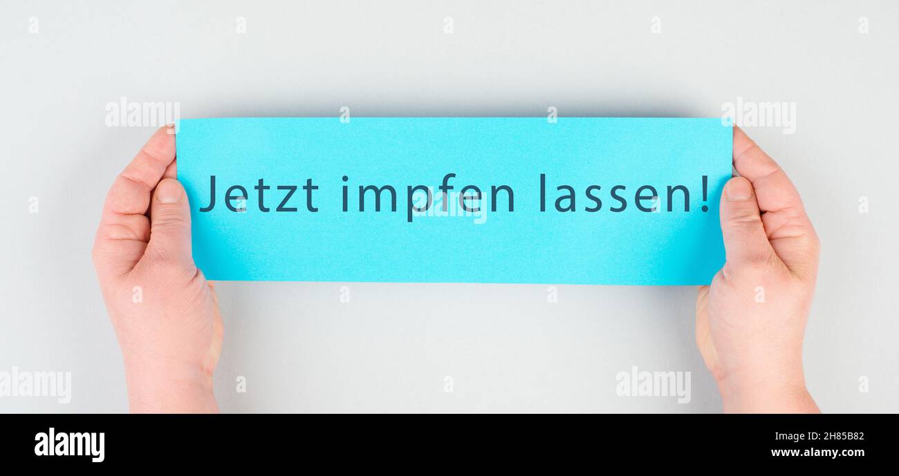 Jetzt impfen lassen steht in deutscher Sprache auf dem Papier, Covid-19-Impfung, Hände mit der Botschaft Stockfoto
