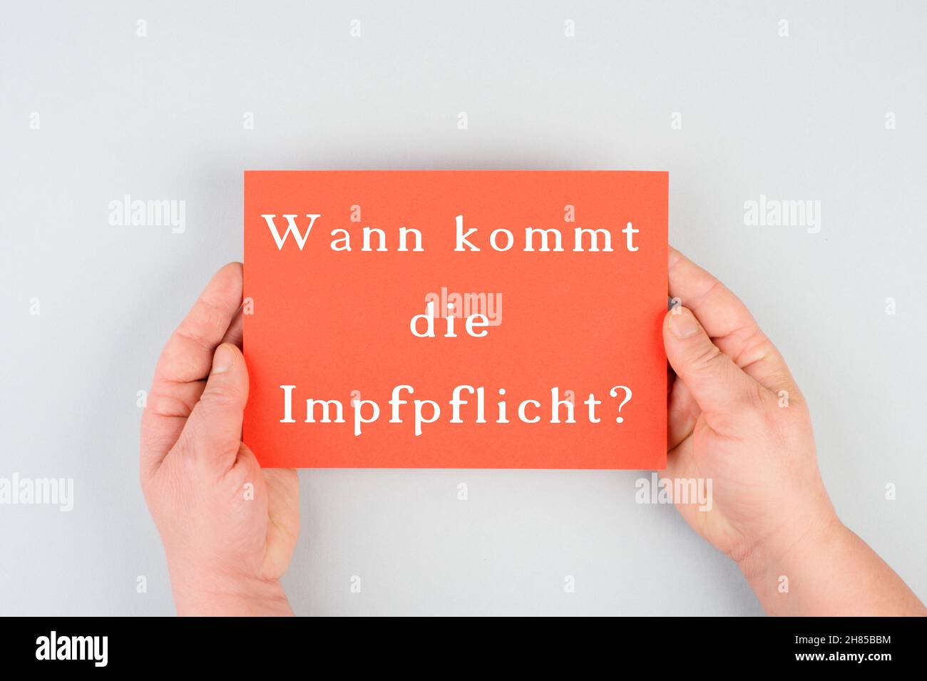 Wann kommt die obligatorische Impfung, steht in deutscher Sprache auf dem rot gefärbten Papier, covid-19 Stockfoto