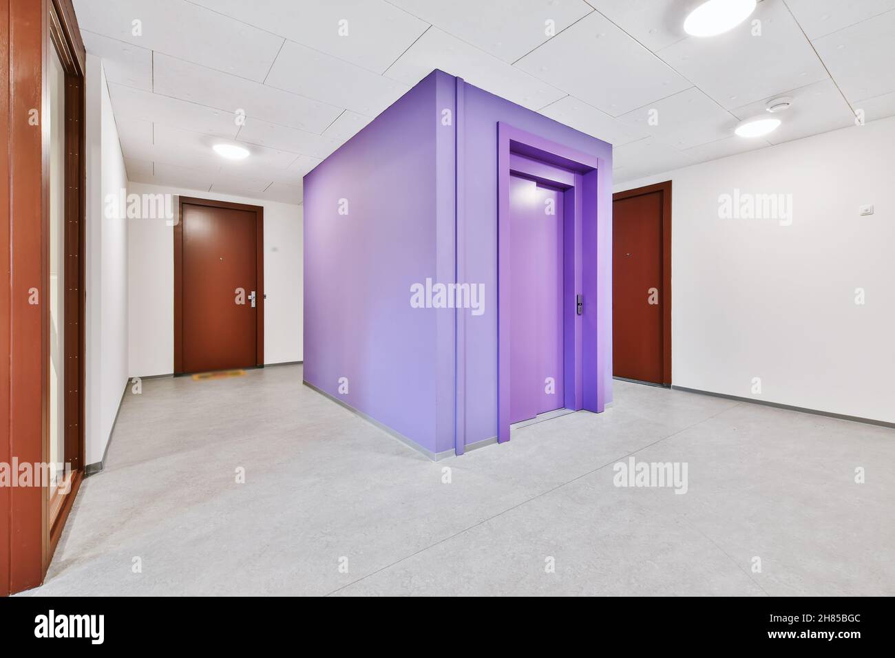 Lila Aufzug in der geräumigen, gemütlichen Lobby Stockfoto