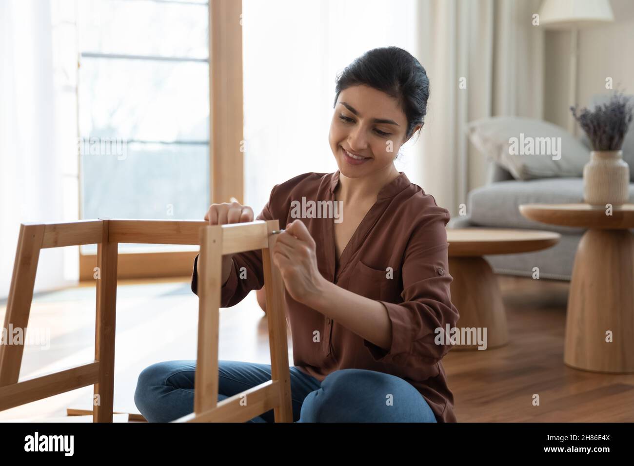 Glücklich schöne junge indische Frau Befestigung Stuhl. Stockfoto