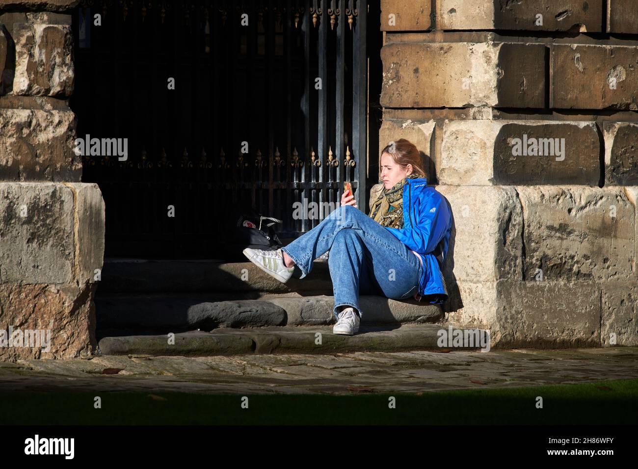 Eine Studentin sitzt in einer Nische vor der Radcliffe Camera Library an der Universität Oxford, England. Stockfoto