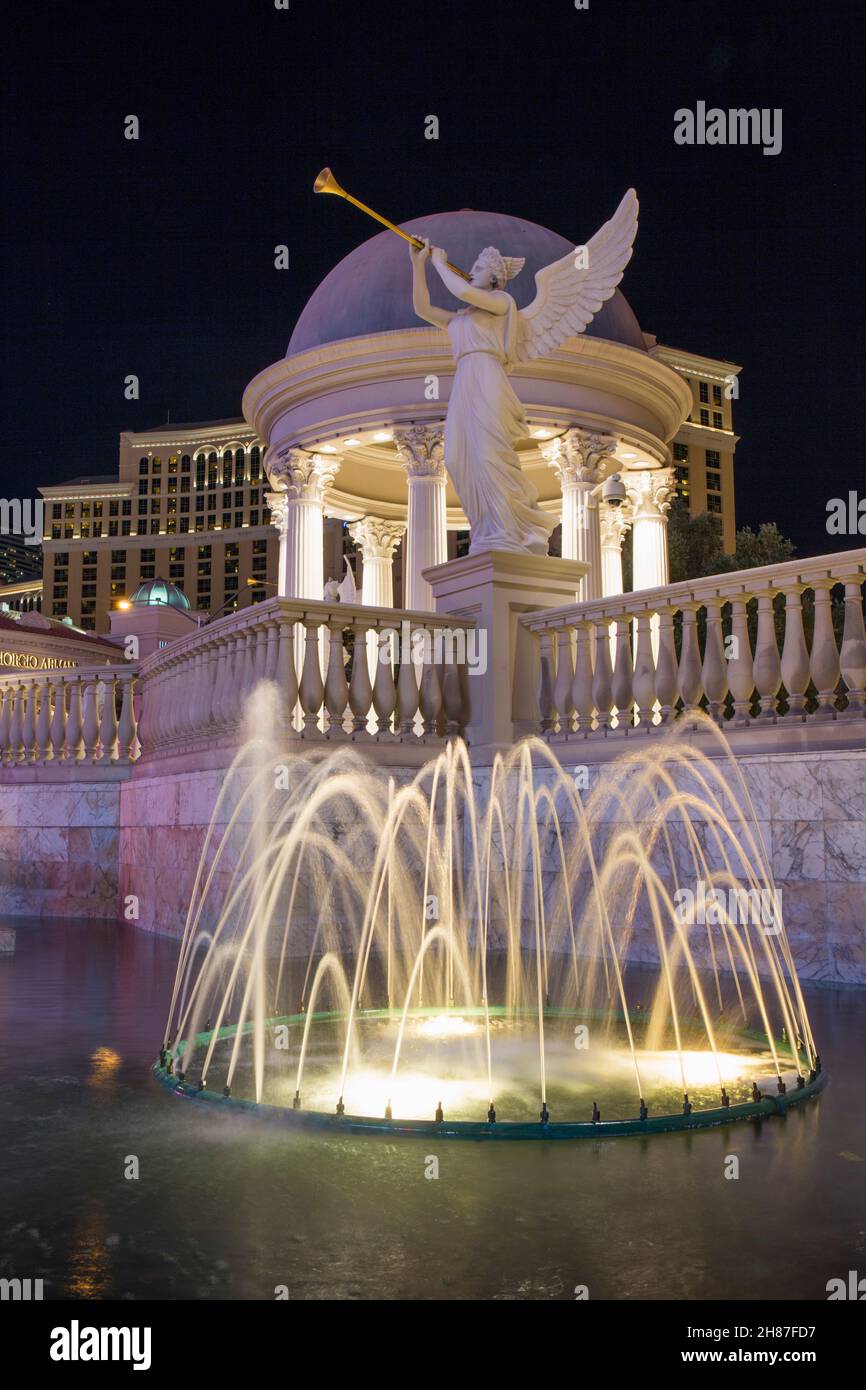 Las Vegas, Nevada, USA. Brunnen vor dem Caesars Palace Hotel und Casino, nachts beleuchtet, Statue von Fama im Hintergrund. Stockfoto