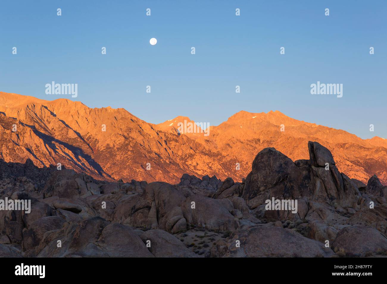 Alabama Hills National Scenic Area, Lone Pine, Kalifornien, USA. Blick bei Mondschein über Felsen auf Mount Williamson und die Sierra Nevada, Sonnenaufgang. Stockfoto
