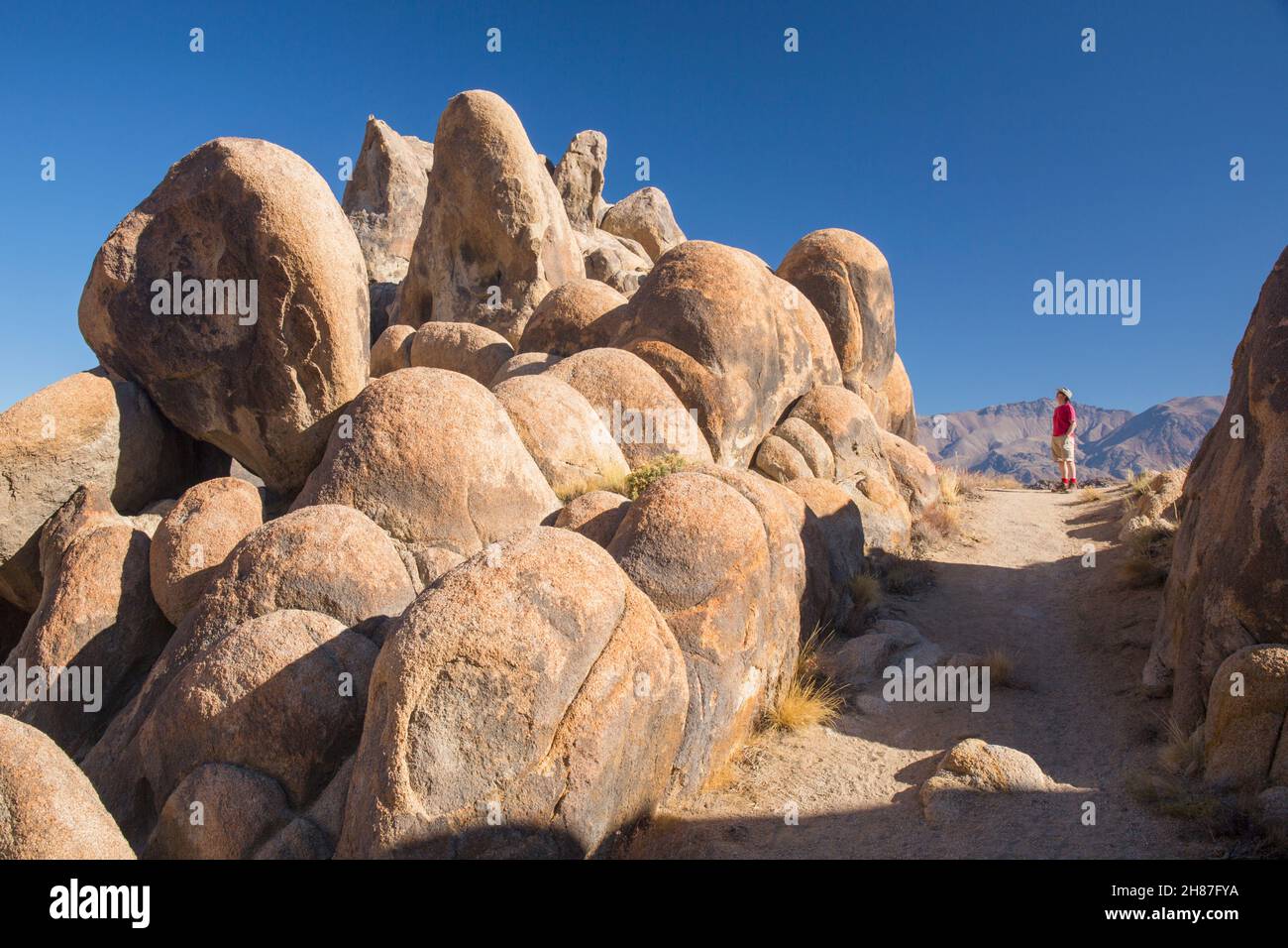 Alabama Hills National Scenic Area, Lone Pine, Kalifornien, USA. Besucher blicken in Ehrfurcht auf die typischen Ausbissen von glatten Granitfelsen. Stockfoto