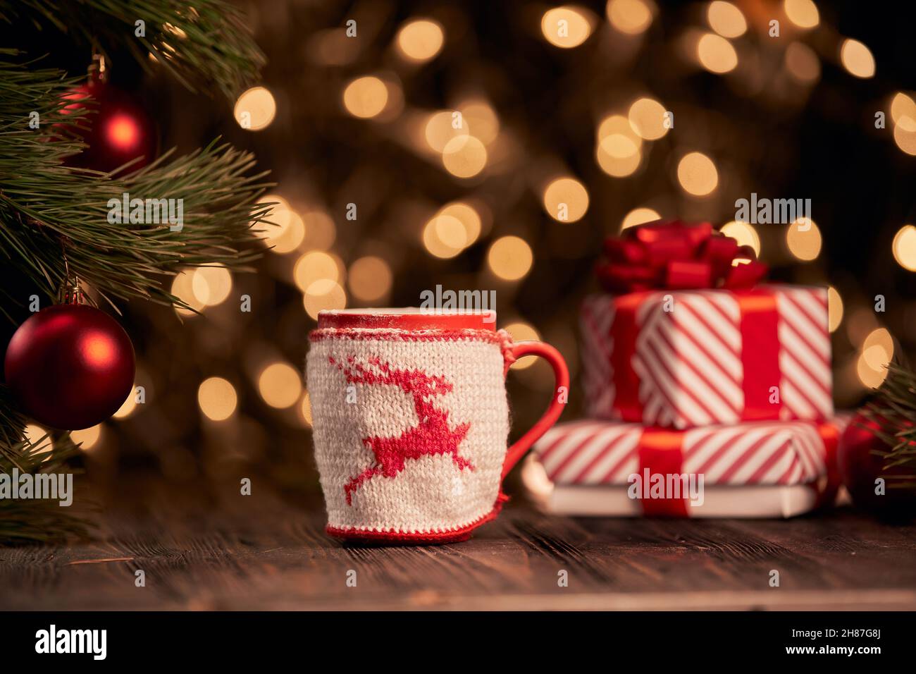 weihnachtsbecher und Geschenkschachteln auf festlichem Hintergrund. Stockfoto