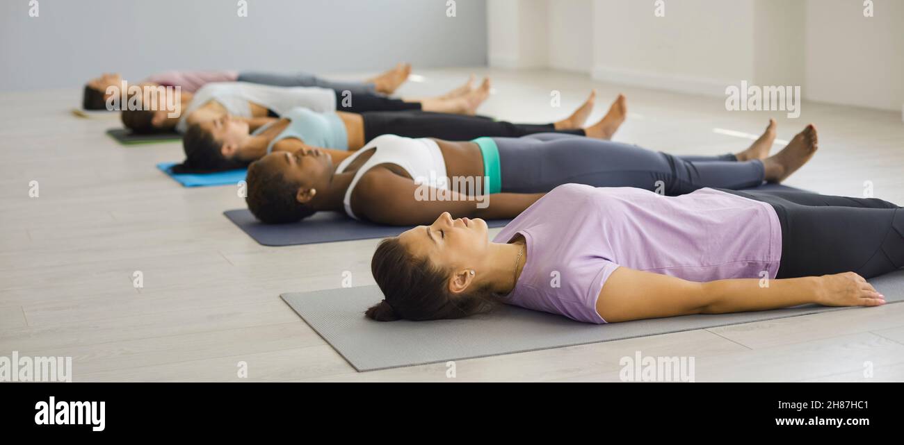 Sportlich-vielfältige Frauen-Gruppenzug meditieren gemeinsam Stockfoto