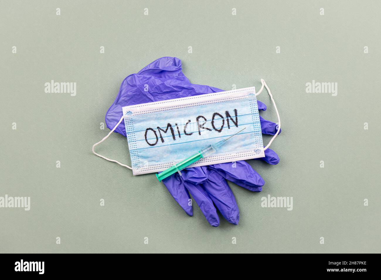 Neues Coronavirus Covid-19 Mutation Omicron Konzept. Medizinische Maske, Spritze und Text mit den Buchstaben Omicron. Stockfoto