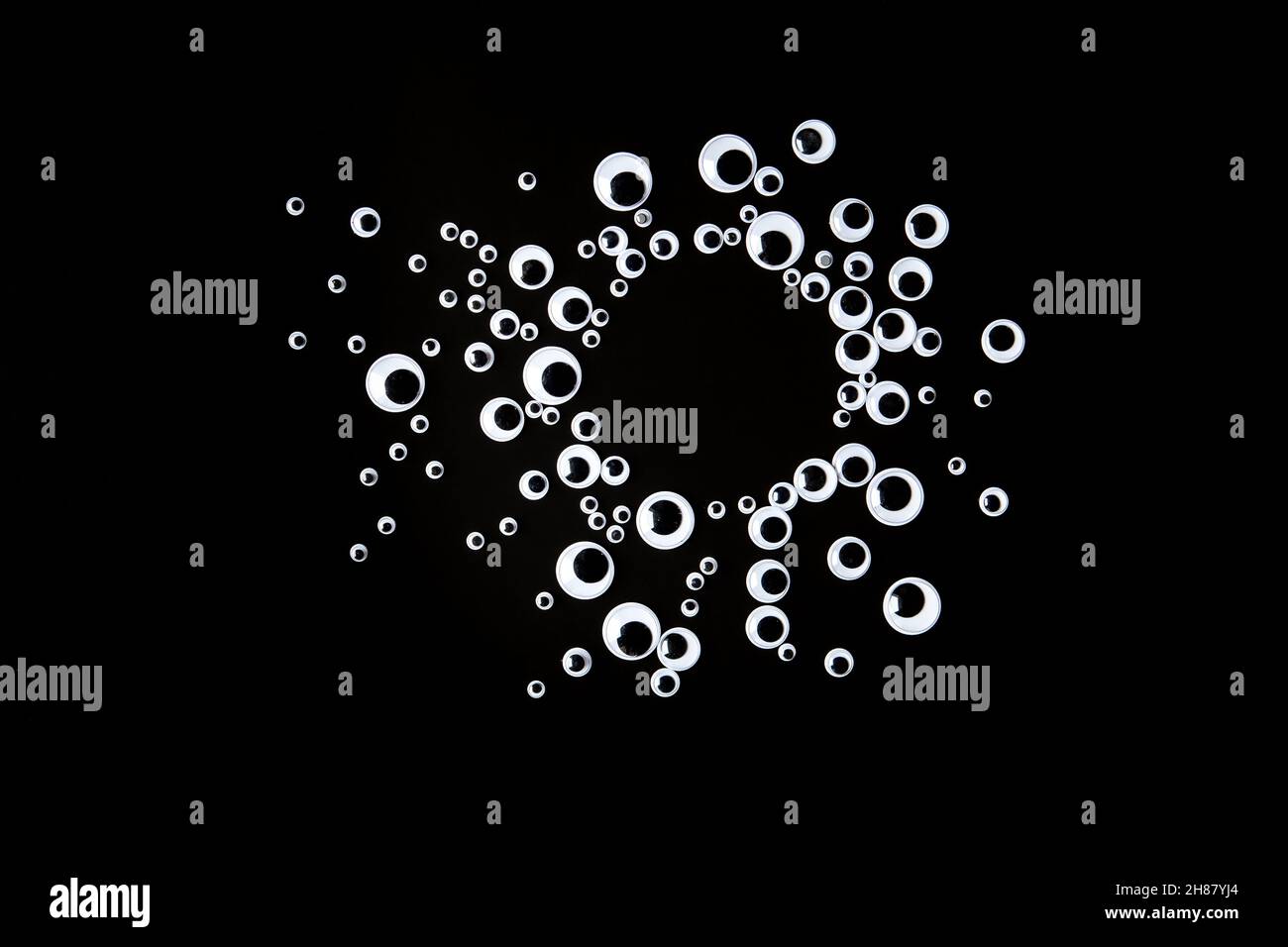 Googly Augen Kunststoff-Spielzeug auf schwarzem Hintergrund Stockfoto