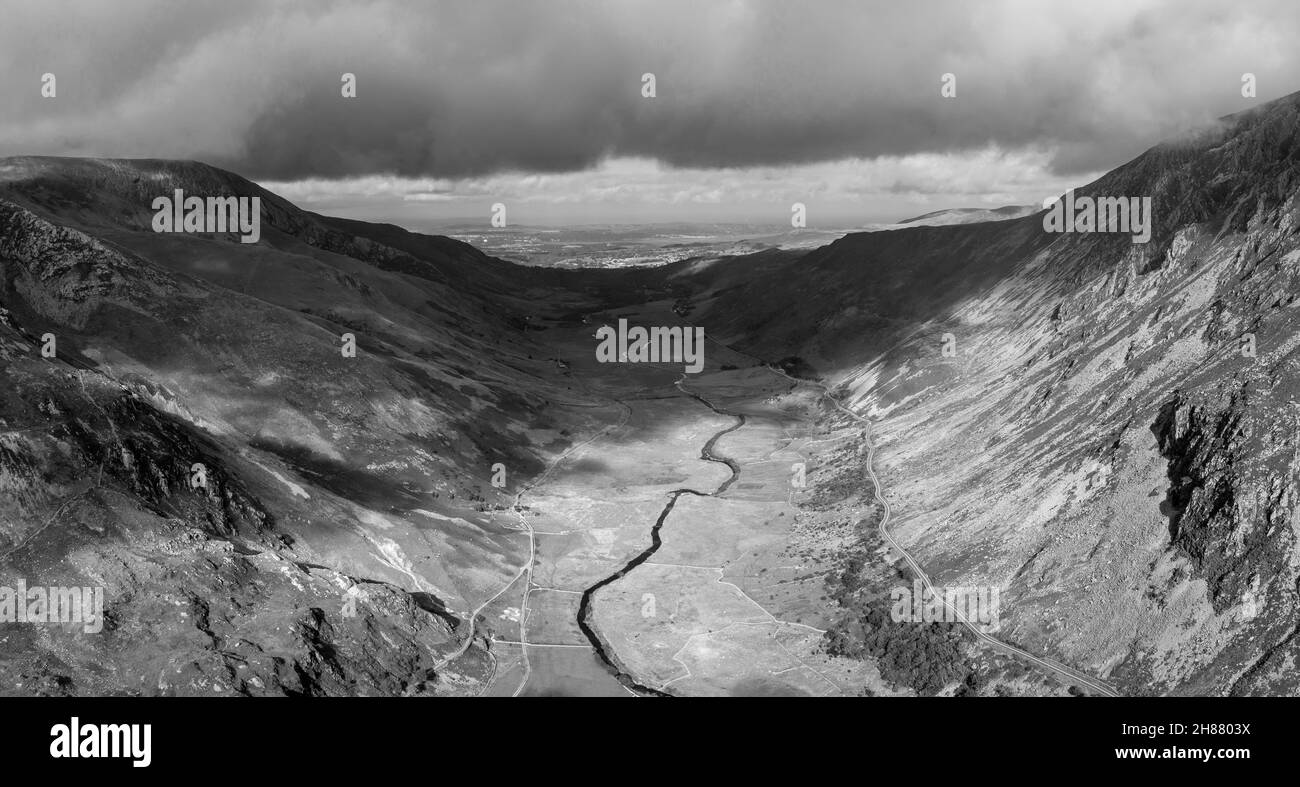 Schwarz-Weiß Luftaufnahme der fliegenden Drohne atemberaubende epische Landschaftsaufnahme im Herbst Blick auf das Nant Fracon Tal von Llyn Idwal dramatischen Himmel und c Stockfoto