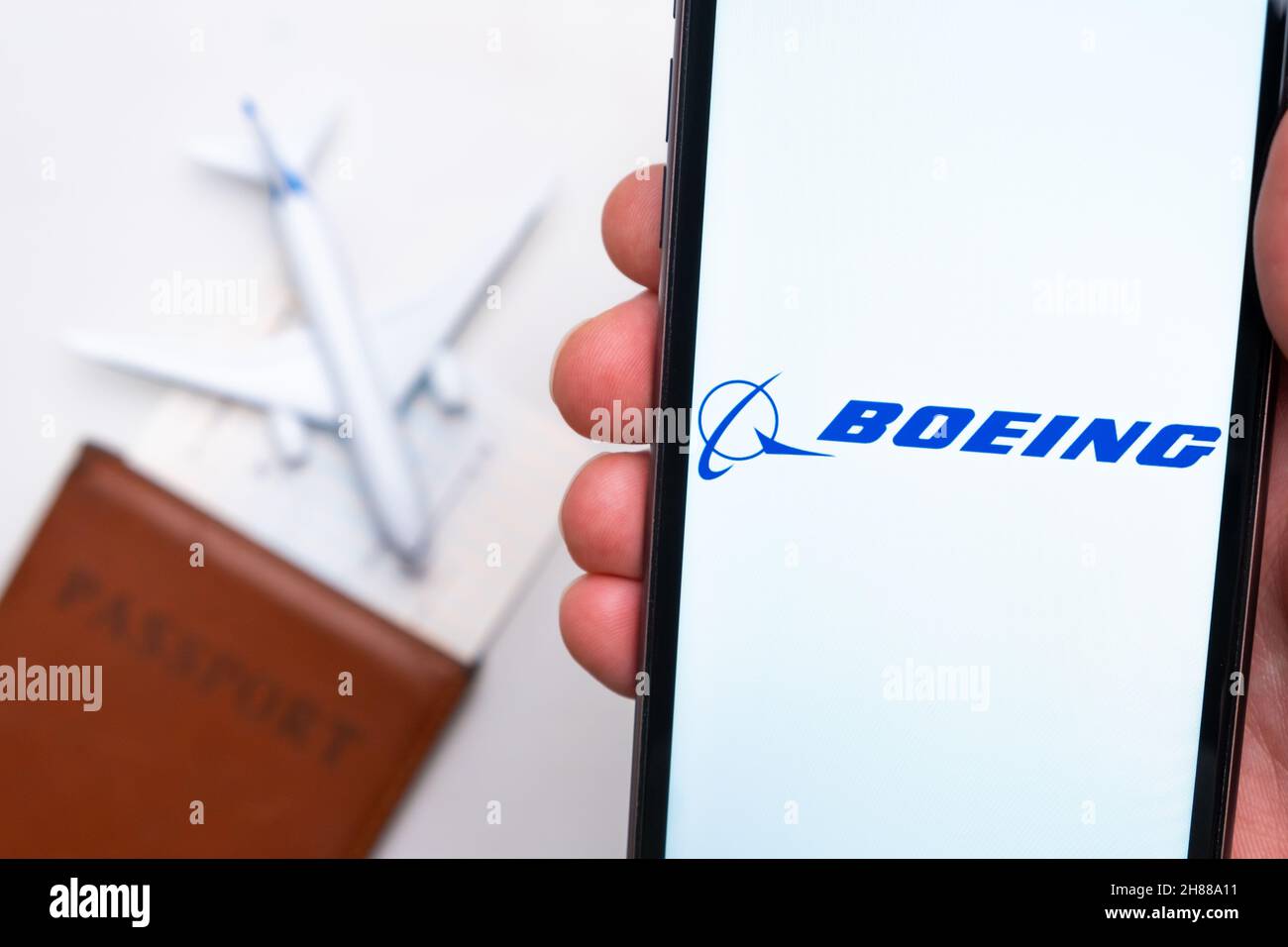 Boeing Airlines App-Logo auf dem Bildschirm des Mobiltelefons. Ein verschwommenes Bild eines Flugzeugs, eines Passes und einer Bordkarte im Hintergrund. November 2021, San Francisco, USA Stockfoto