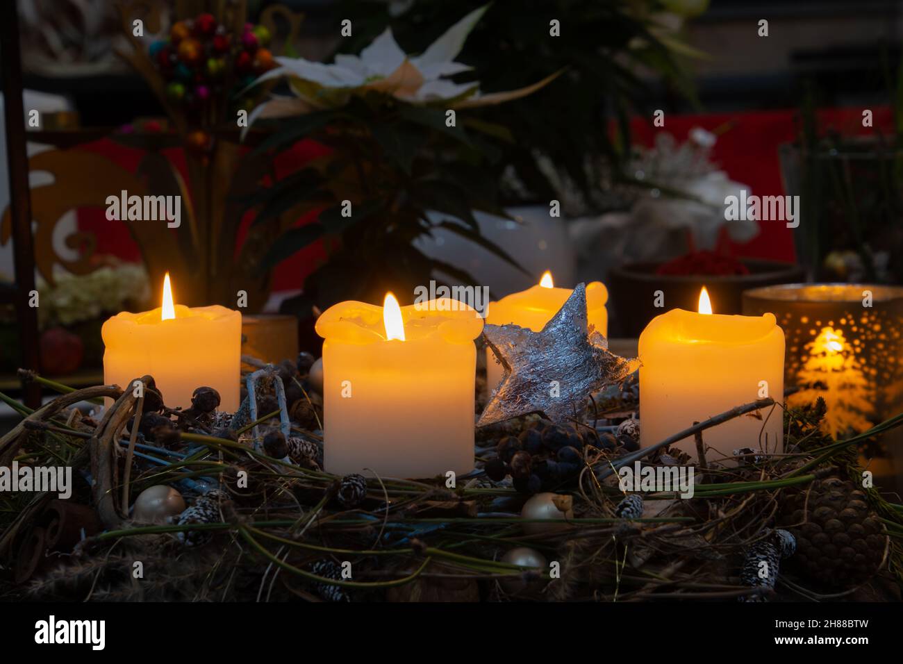 Weihnachtskranz mit brennenden weißen Kerzen und weihnachtsdekoration und Kopierraum Stockfoto