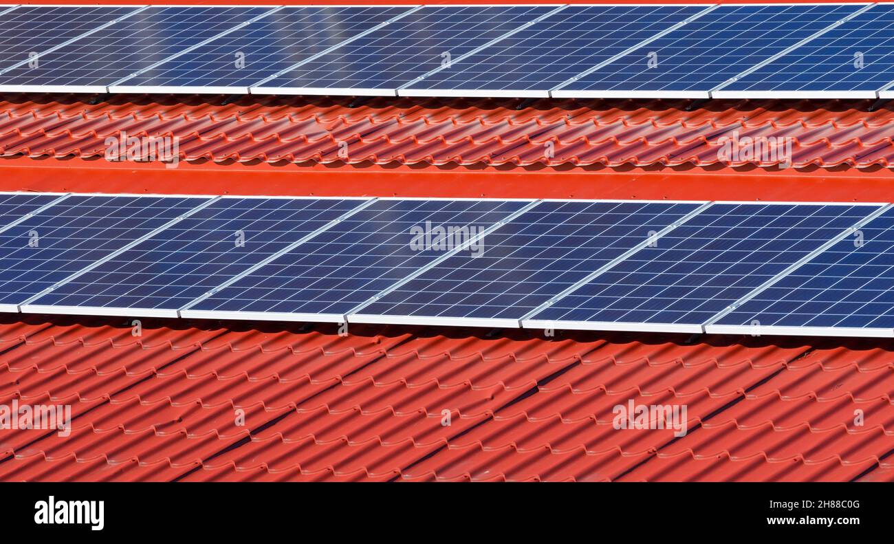 Sonnenkollektoren auf rotem Zinndach, Finnland Stockfoto