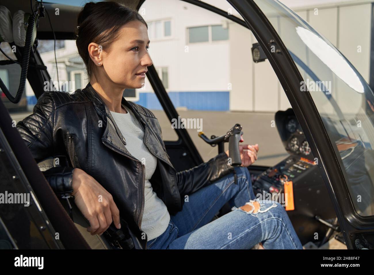 Elegante Frau, die in der Kabine eines Hubschraubers posiert Stockfoto