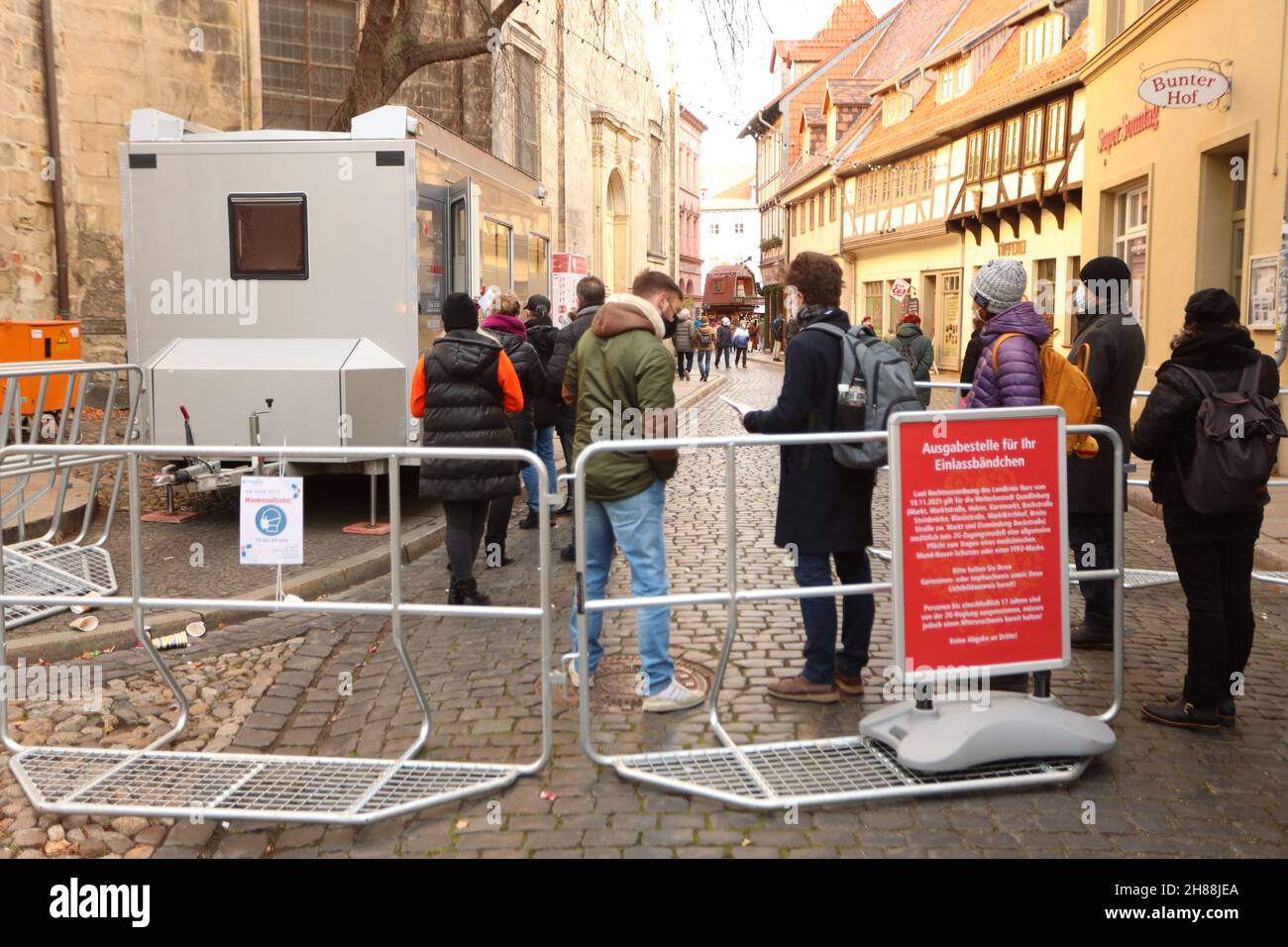 Quedlinburg, Deutschland. 28th. November 2021. Besucher warten vor einer Ausgabestelle auf ihre Eintrittsarmbänder für den Weihnachtsmarkt in der Adventstadt Quedlinburg. Der Weihnachtsmarkt ist einer der beiden Märkte, die im Landkreis Harz unter besonders hohen Corona-Bedingungen eine Freilassungserlaubnis erhalten haben. Quelle: Matthias Bein/dpa-Zentralbild/dpa/Alamy Live News Stockfoto