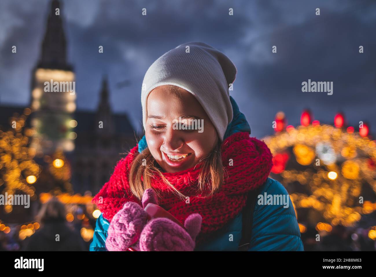 Junge Frau trinkt Glühwein auf dem weihnachtsmarkt in Wien, Österreich. Fröhlicher Tourist, der während der weihnachtsferien Urlaub genießt. Heißes Getränk Stockfoto