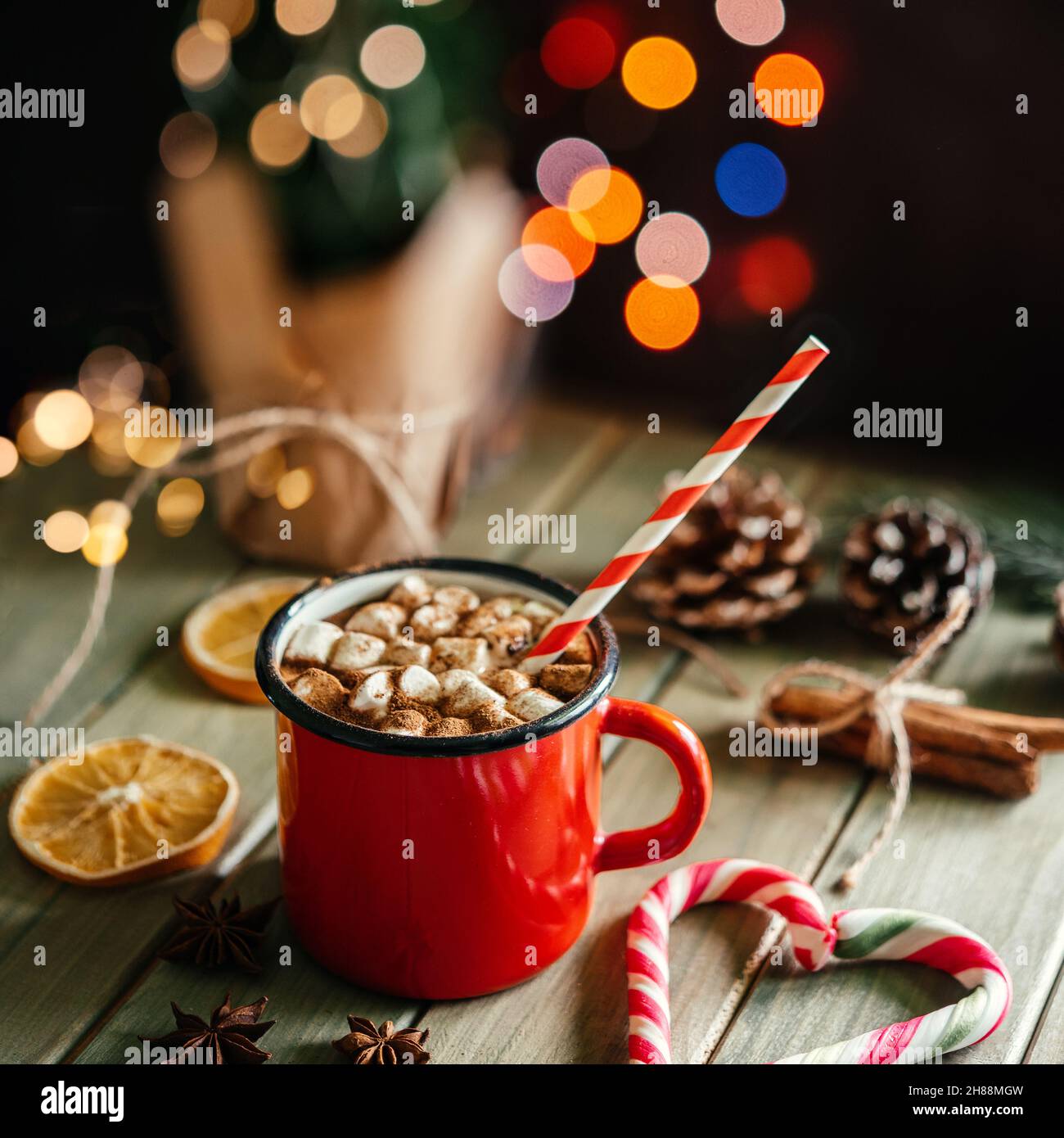 Roter emaillierter Becher mit heißer Schokolade mit Marschmalin auf weihnachtlichem Hintergrund Stockfoto
