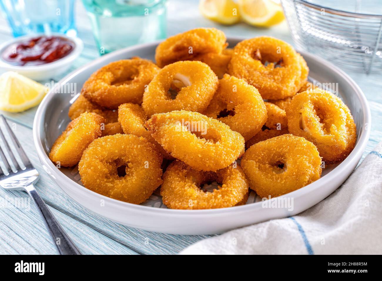 Köstliche knusprige panierte und gebratene Calamari mit Zitronen- und Meeresfrüchtegerauce. Stockfoto
