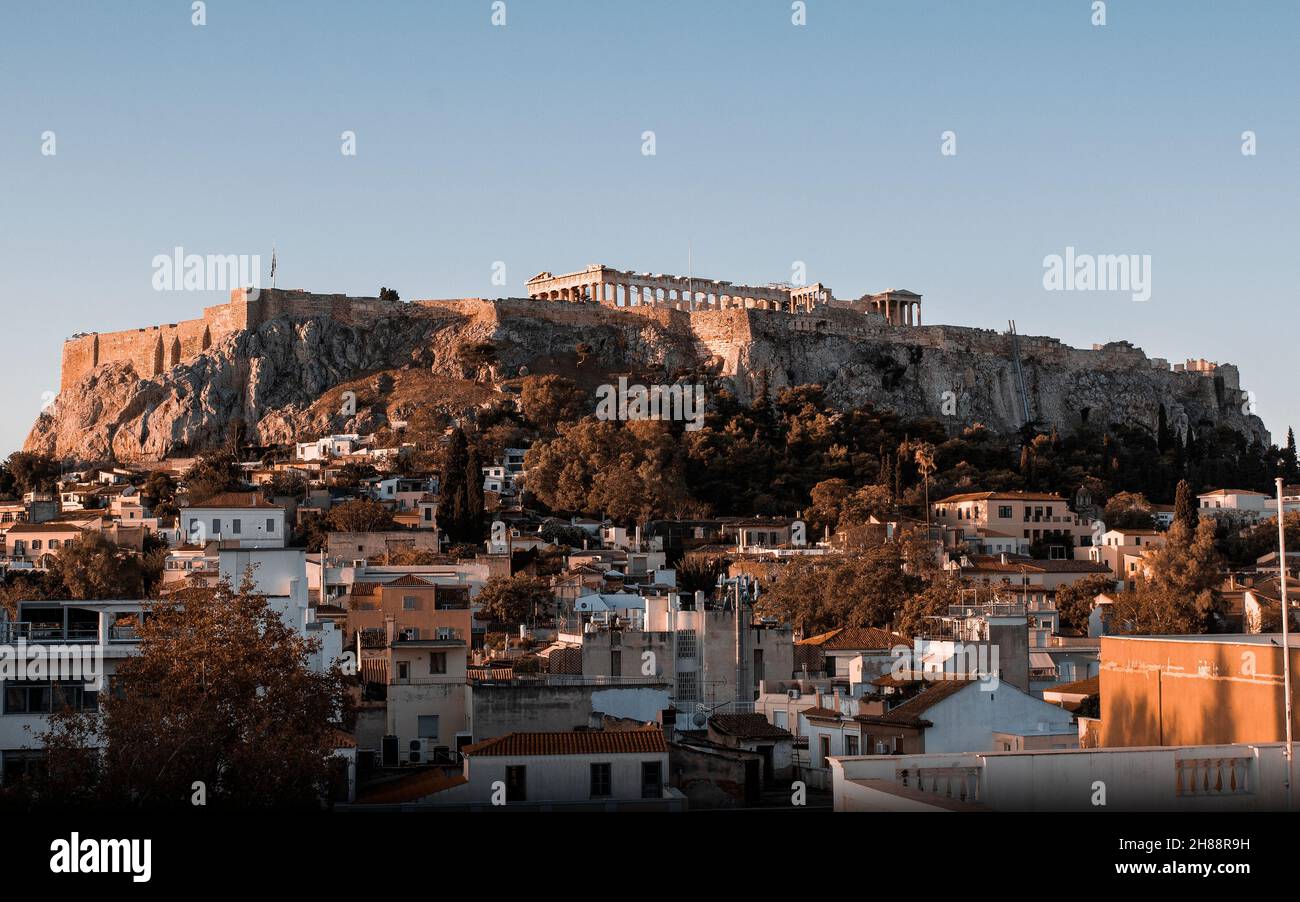 Ein wunderschöner Sonnenuntergang über dem Parthenon und der Akropolis von Athen auf dem Akropolis-Hügel mit Blick auf die Altstadt von Athen. Stockfoto