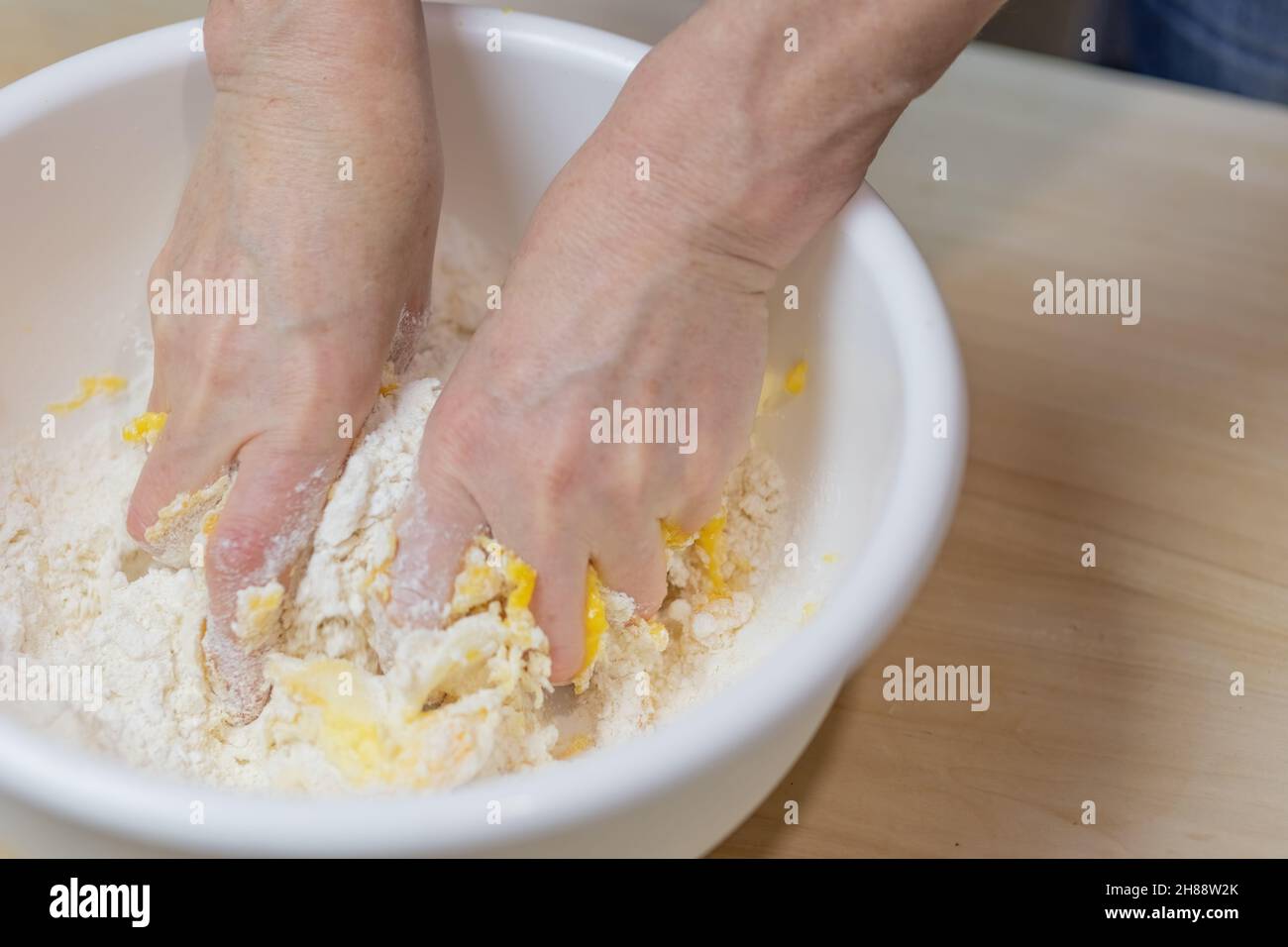 Weibliche Hände verarbeiten Teig zum Backen von Nahaufnahme in der Küche. Horizontal. Stockfoto