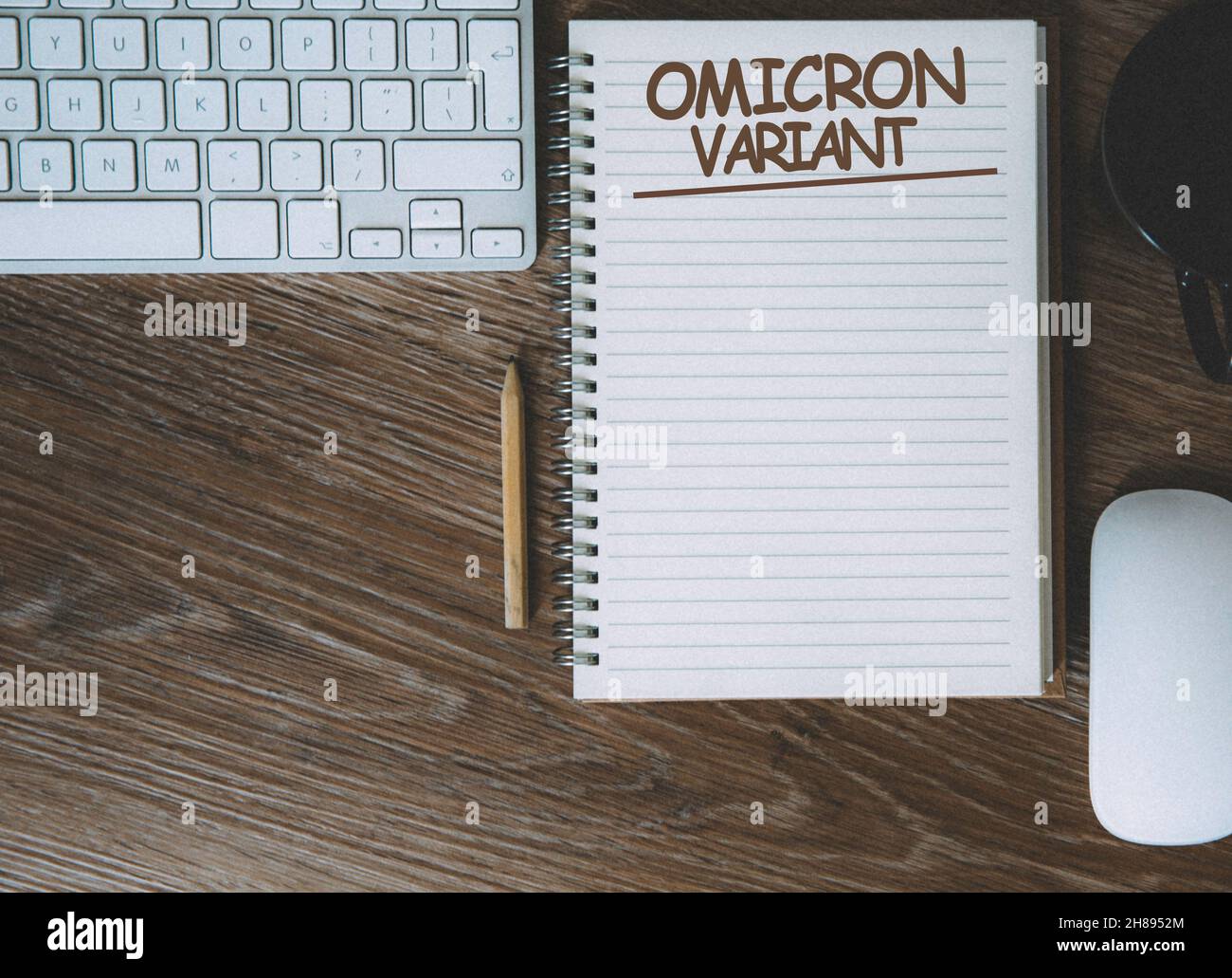 Schreibtisch und Notizbuch mit dem Titel „Omicron-Variante von Coronavirus“ und Kopierbereich Stockfoto