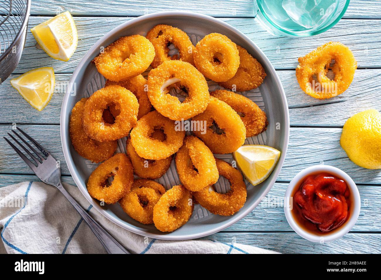 Köstliche knusprige panierte und gebratene Calamari mit Zitronen- und Meeresfrüchtegerauce. Stockfoto
