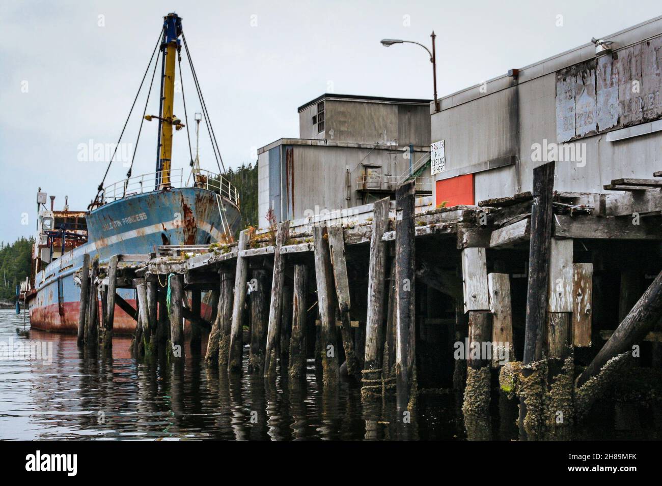 Das rostende alte Schiff, Chilcotin Princess, wurde an den baufälligen Pier in Namu gebunden, einer verlassenen Cannery Town in der Inside Passage von BC (2009). Stockfoto