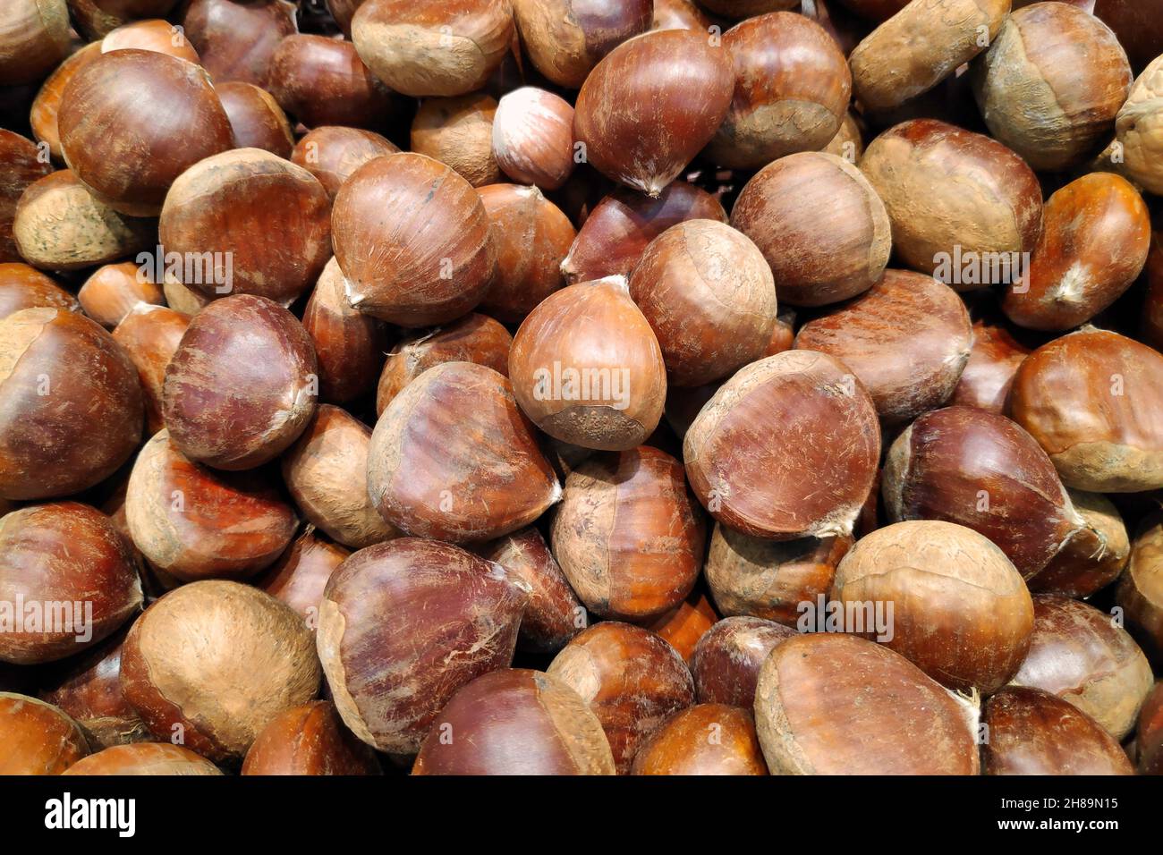 Nahaufnahme eines Kastanienstapels zum Verkauf an einem Marktstand. Stockfoto