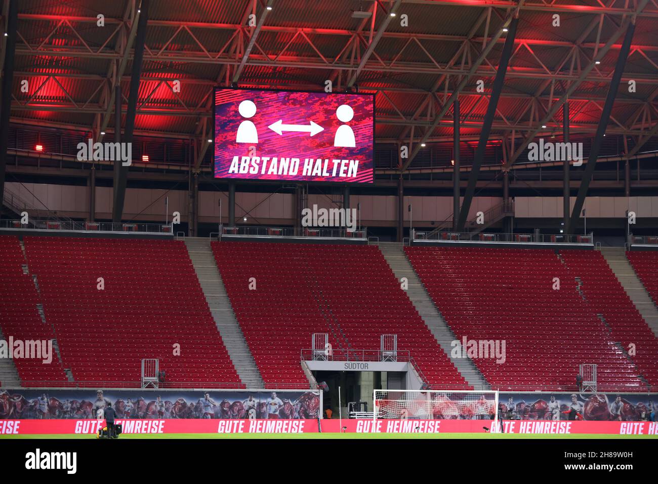 Leipzig, Deutschland. 28th. November 2021. Fußball, Bundesliga, RB Leipzig - Bayer Leverkusen, Matchday 13 in der Red Bull Arena. „Halten Sie Ihre Distanz“ steht auf der Anzeigetafel über den leeren Ständen. Auf den Werbetafeln am Rande der Werbeflächen steht „eine sichere Heimreise“. WICHTIGER HINWEIS: Gemäß den Anforderungen der DFL Deutsche Fußball Liga und des DFB Deutscher Fußball-Bundes ist es untersagt, im Stadion und/oder des Spiels aufgenommene Fotos in Form von Sequenzbildern und/oder videoähnlichen Fotoserien zu verwenden oder zu verwenden. Quelle: Jan Woitas/dpa/Alamy Live News Stockfoto