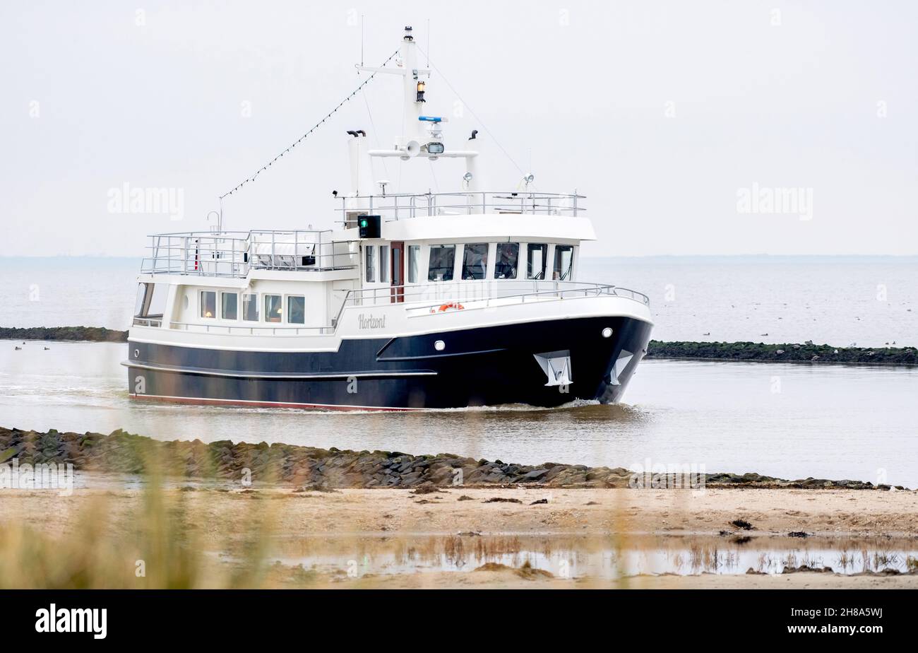 Harlesiel, Deutschland. 27th. November 2021. Das Schiff 'Horizont' der Albrecht Funeral Shipping Company fährt bei bewölktem Wetter in den Hafen. Das Schiff wurde ausschließlich für Bestattungen auf See gebaut und ausgestattet und 2009 von der Reederei in Betrieb genommen. Quelle: Hauke-Christian Dittrich/dpa/Alamy Live News Stockfoto