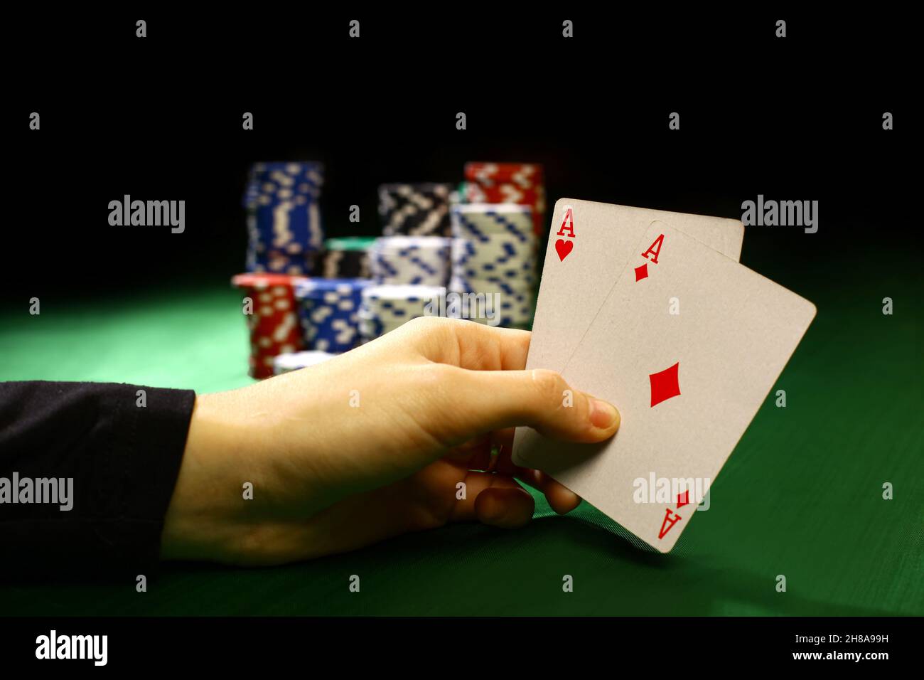 Poker chips und einer Hand, drehe die Karten gegen Grün isoliert fühlte Stockfoto